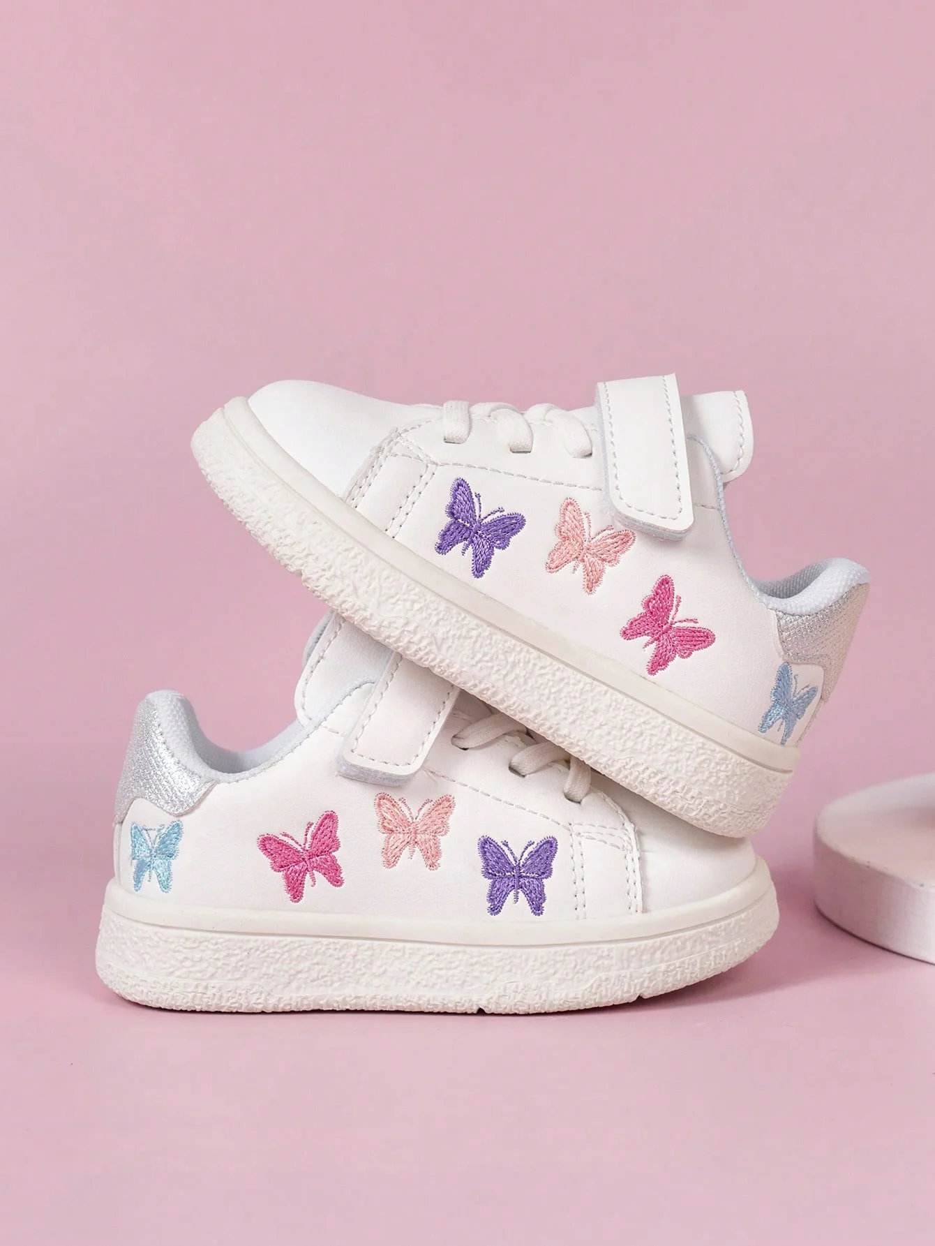 A pair of children's casual white shoes embroidered with butterflies; children's flat sports shoes.
A pair of children's casual white shoes embroidered with butterflies; children's flat sports shoes.