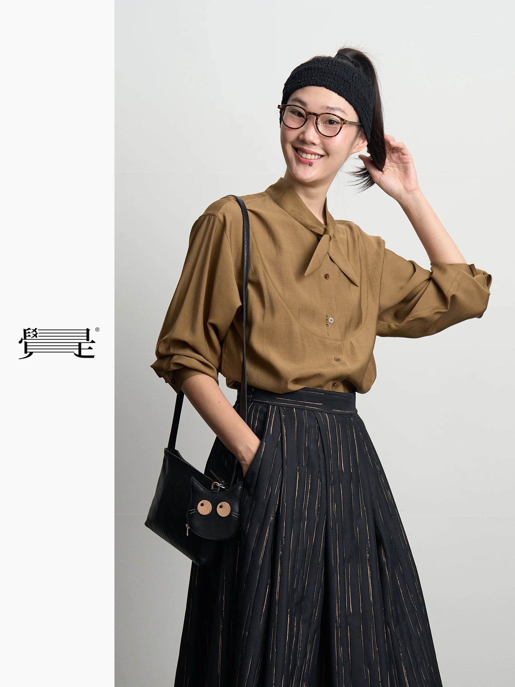 Карамельно-коричневая рубашка с воротником-стойкой, декором в виде банта и кроличьих ушек от Jue i Original Design, женская повседневная модная одежда для работы и отдыха.
Карамельно-коричневая рубашка с воротником-стойкой, декором в виде банта и кроличьих ушек от Jue i Original Design, женская повседневная модная одежда для работы и отдыха.