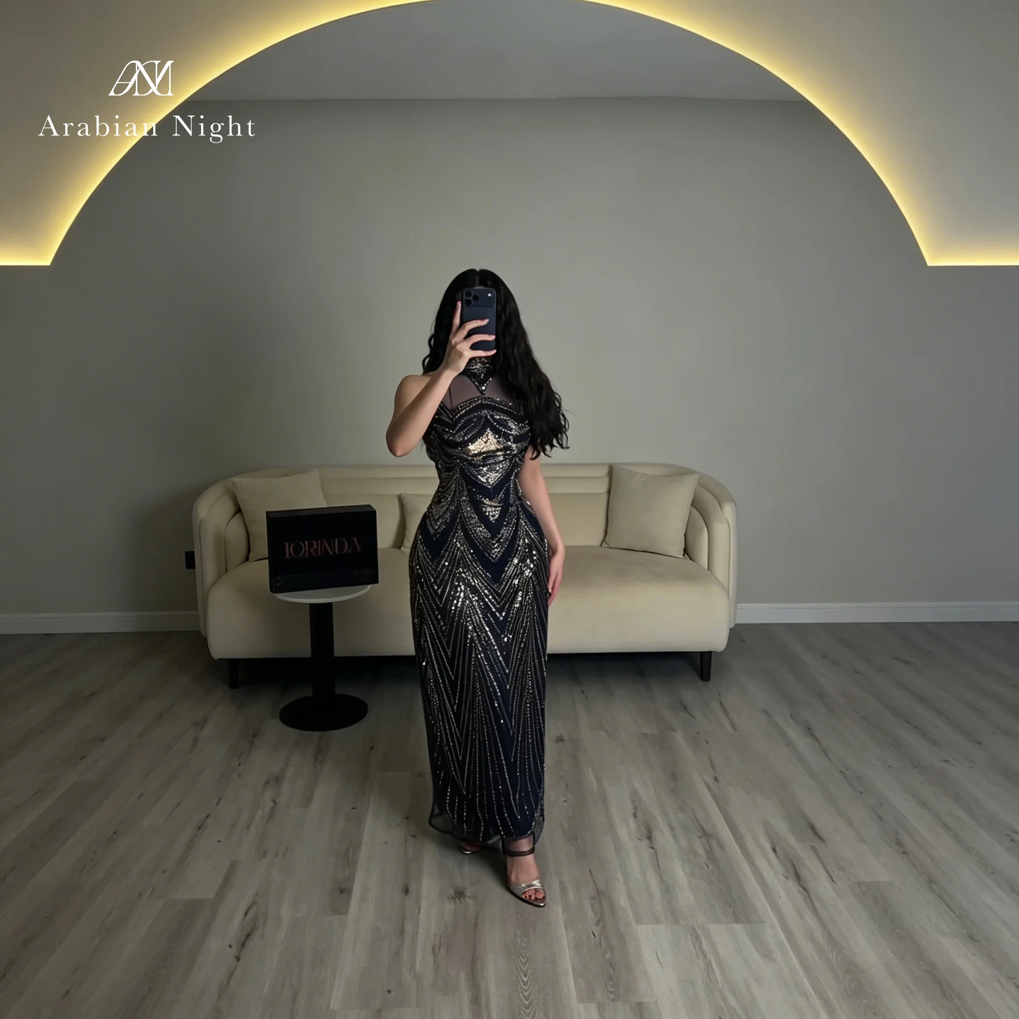 An elegant navy blue high-necked, sleeveless, floor-length mermaid gown, adorned with metallic sequins, shimmering and dazzling.
An elegant navy blue high-necked, sleeveless, floor-length mermaid gown, adorned with metallic sequins, shimmering and dazzling.