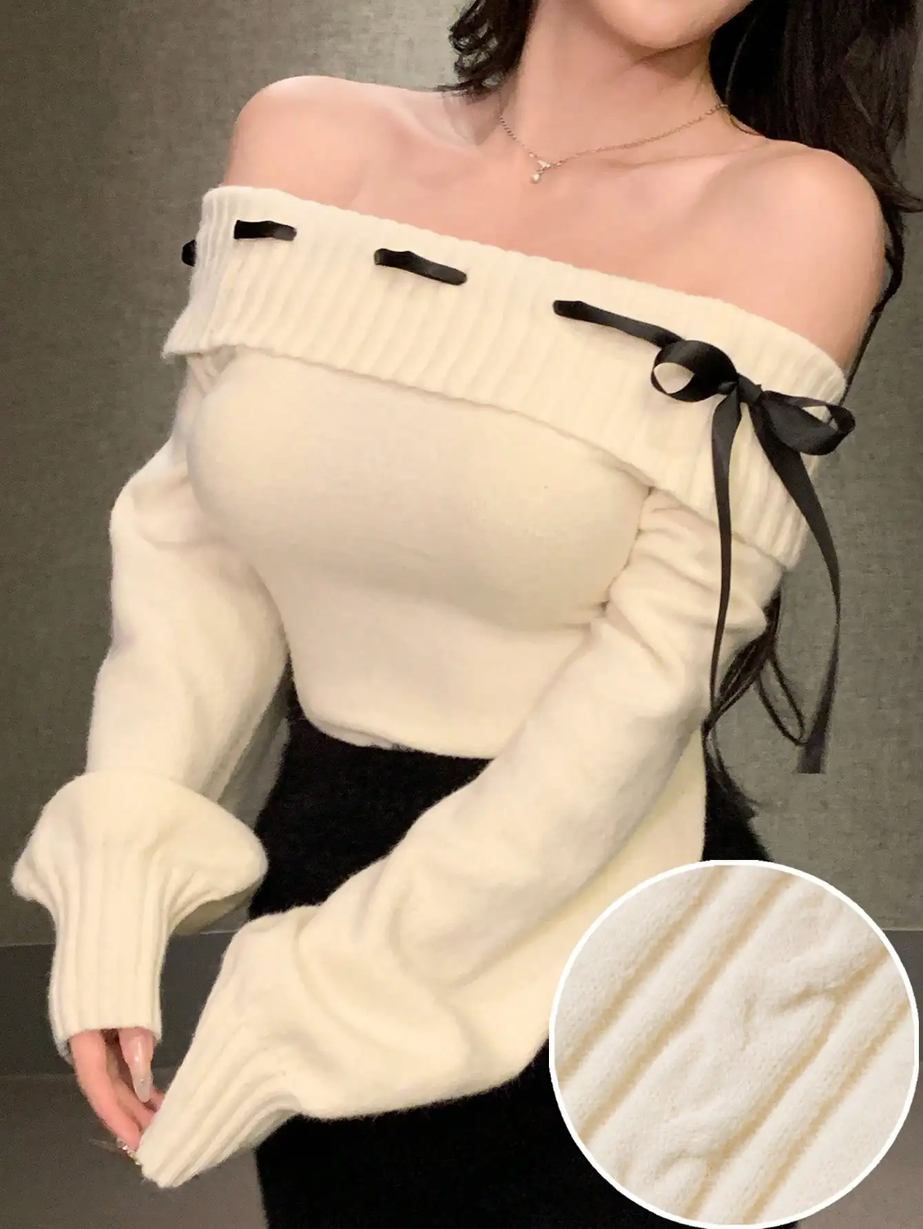 Кремовый вязаный свитер с открытыми плечами, черными ленточными бантиками, длинными рукавами и укороченным кроем.
Кремовый вязаный свитер с открытыми плечами, черными ленточными бантиками, длинными рукавами и укороченным кроем.