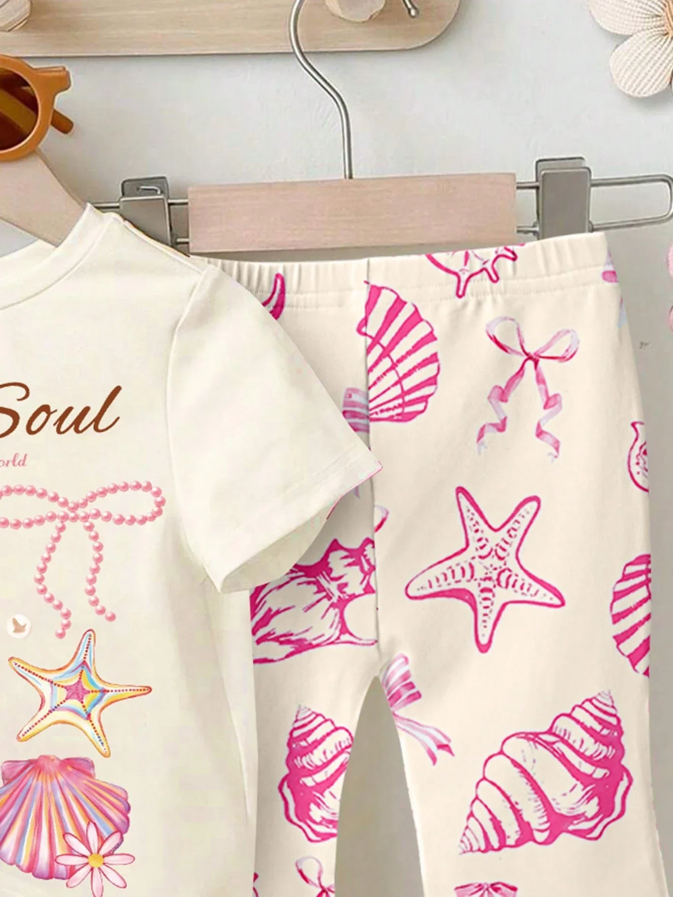 Adorable Baby Girl Summer Set: Cream Tee With Starfish, Shell & Bow Print + Matching Flare Pants For Beach And Casual Wear
Adorable Baby Girl Summer Set: Cream Tee With Starfish, Shell & Bow Print + Matching Flare Pants For Beach And Casual Wear