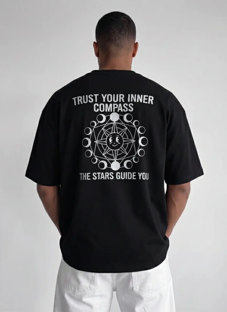Black Celestial Graphic Tee with "Trust Your Inner Compass" Back Print, Moon Phases, Smiling Moon Emblem, White Ink Bold Artwork
Black Celestial Graphic Tee with "Trust Your Inner Compass" Back Print, Moon Phases, Smiling Moon Emblem, White Ink Bold Artwork