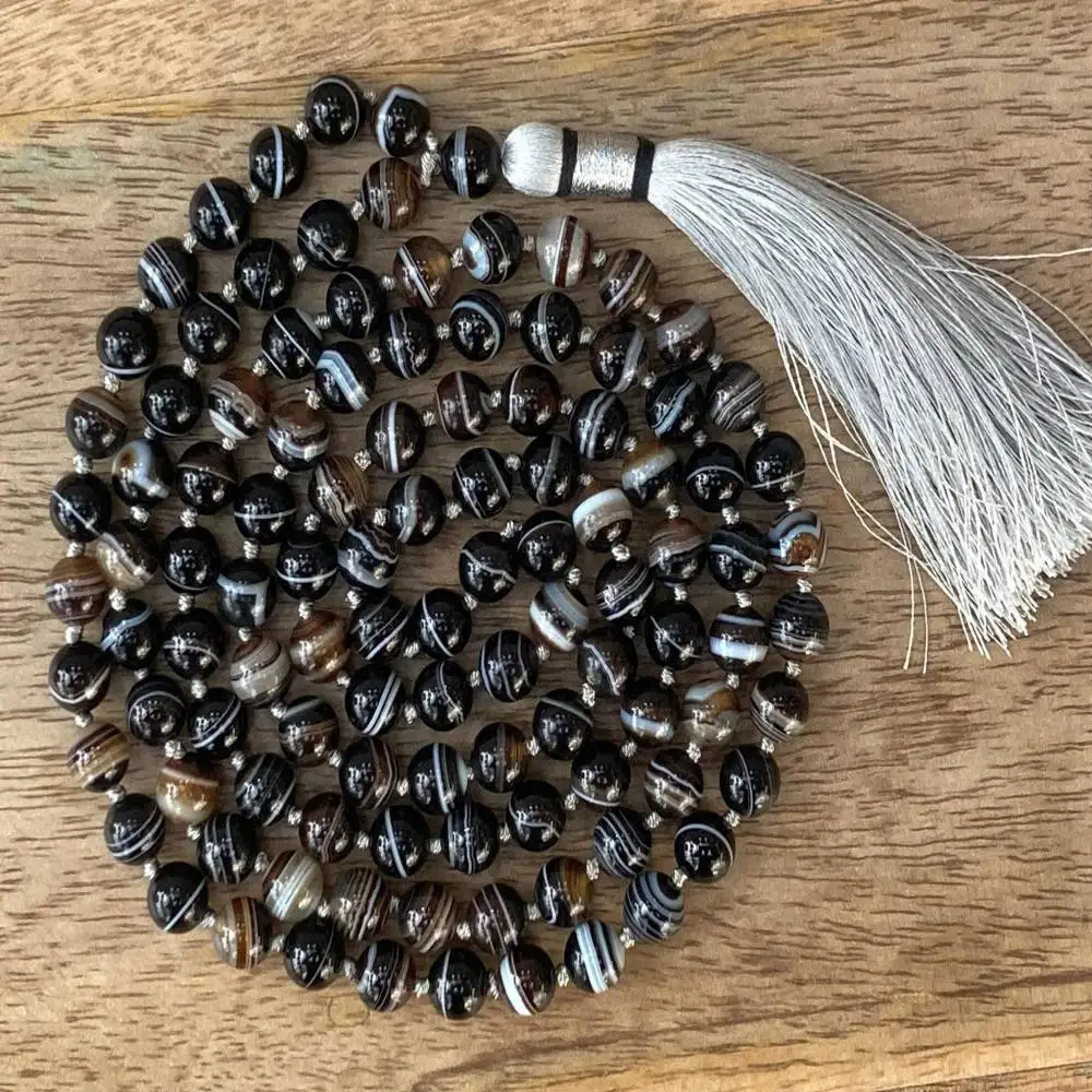 Натуральное ожерелье-мала из полосатого агата (108 бусин) с белым кисточком: целебный кристалл для защиты и стабильности
Натуральное ожерелье-мала из полосатого агата (108 бусин) с белым кисточком: целебный кристалл для защиты и стабильности