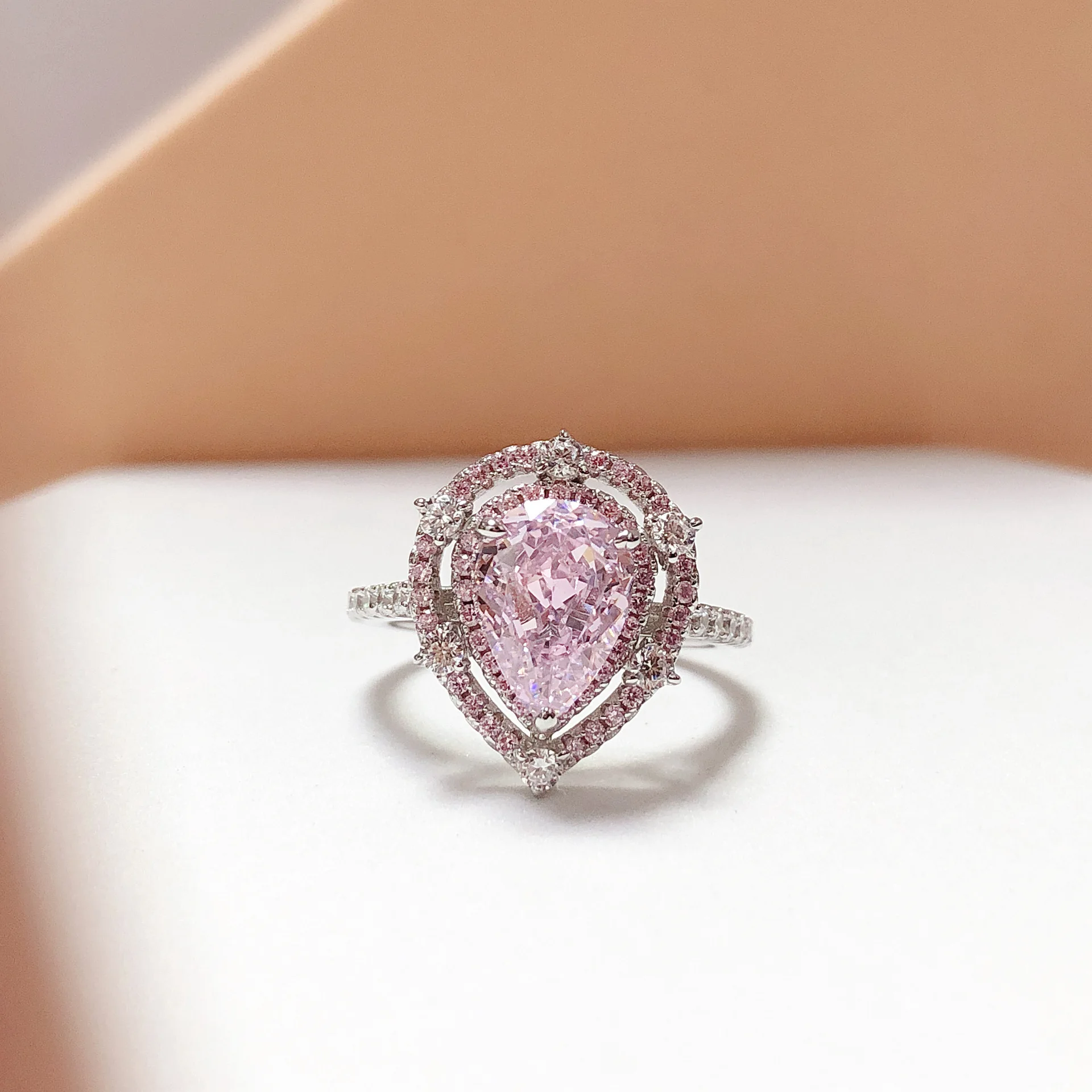 Platinum PT950 pink 2-carat teardrop ring, with a girl-themed setting of pink small diamonds surrounding the ring bezel.
Platinum PT950 pink 2-carat teardrop ring, with a girl-themed setting of pink small diamonds surrounding the ring bezel.