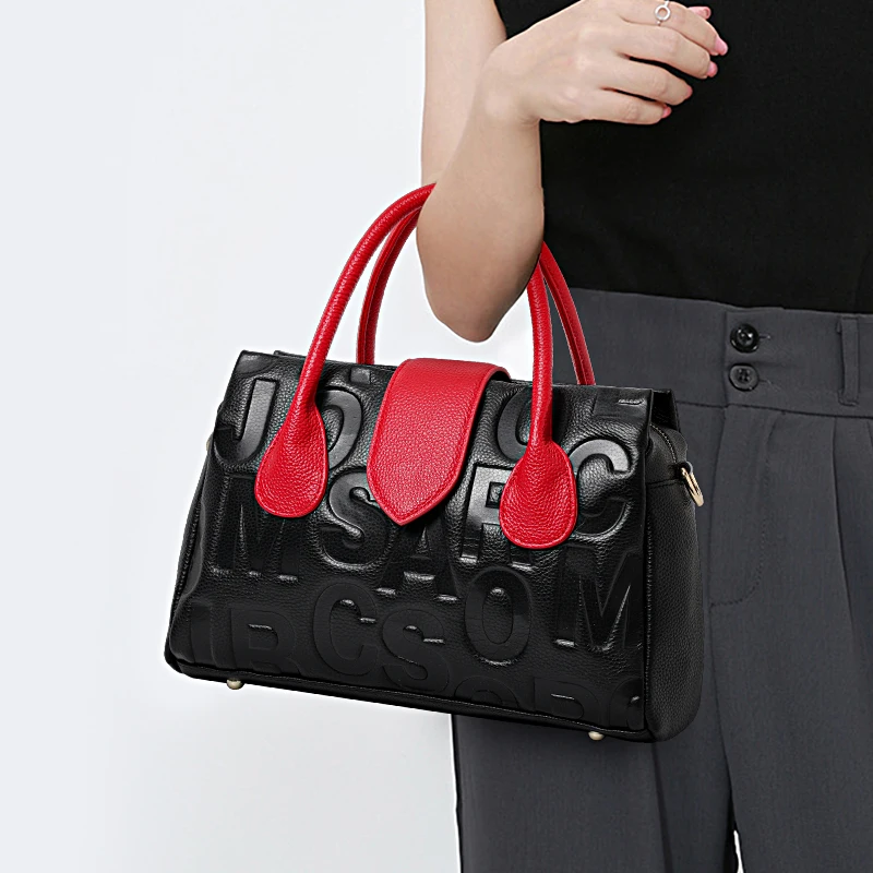 Структурованная черная сумка Aidrani: кожа премиум-класса с тиснением алфавита и красными акцентами 
Структурованная черная сумка Aidrani: кожа премиум-класса с тиснением алфавита и красными акцентами