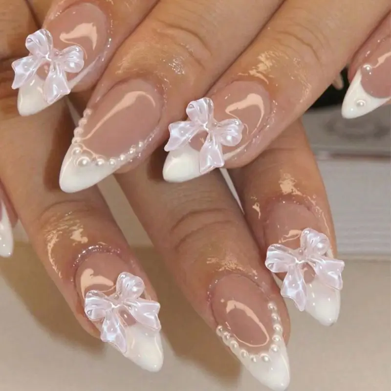 Valentine’s Day press-on nails: white almond-shaped French tips with pearl and bow accents—stylish false nail stickers.
Valentine’s Day press-on nails: white almond-shaped French tips with pearl and bow accents—stylish false nail stickers.