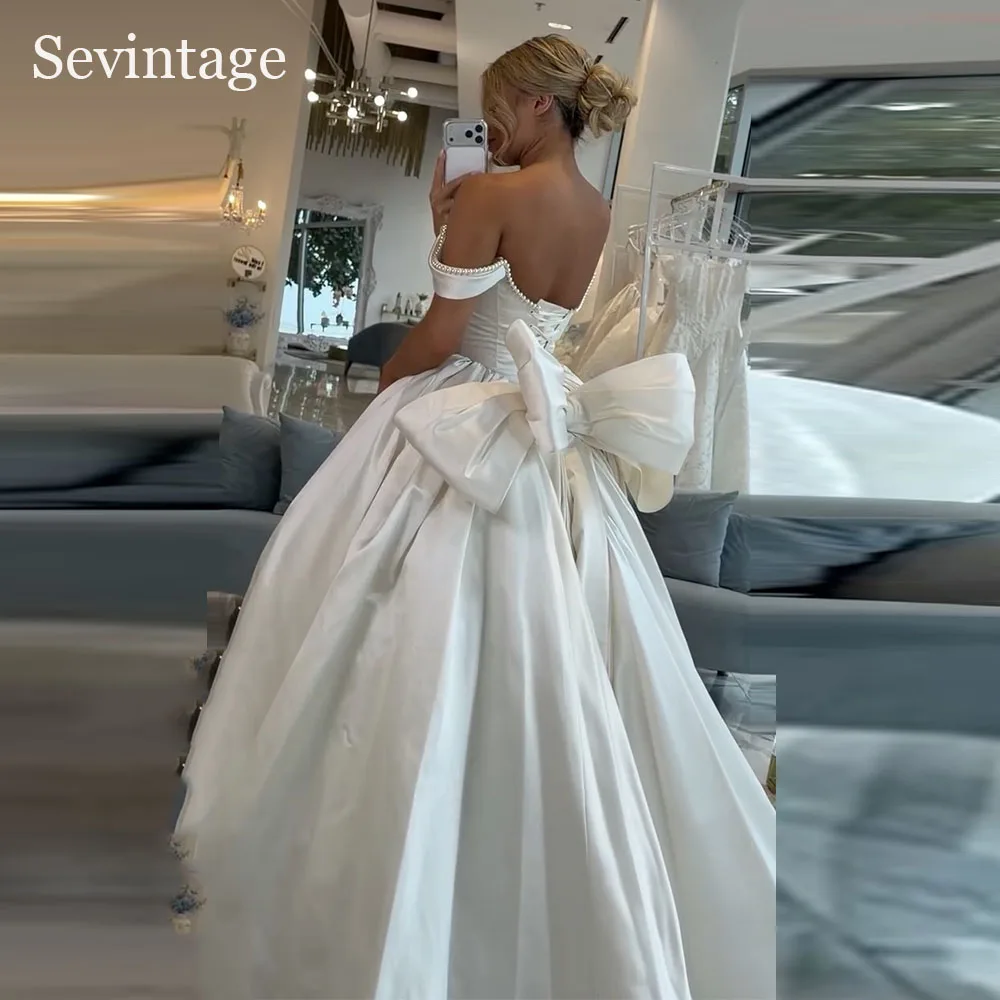 Sevintage Luxury Satin Wedding Dresses Bow Back Pearls Bridal Gowns Off The Shoulder A-Line Pleated Bride Dresses 2026 Customize
Sevintage Luxury Satin Wedding Dresses Bow Back Pearls Bridal Gowns Off The Shoulder A-Line Pleated Bride Dresses 2026 Customize