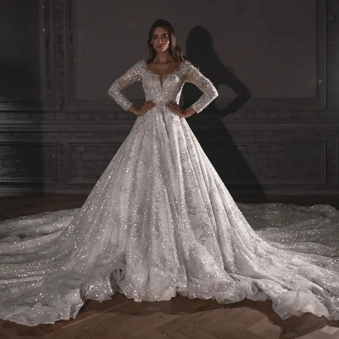 Блестящее бальное платье Свадебные платья с длинными рукавами и V-образным вырезом с блестками 3D кружево с бриллиантами Свадебные платья из бисера Vestina De Novia по индивидуальному заказу
Блестящее бальное платье Свадебные платья с длинными рукавами и V-образным вырезом с блестками 3D кружево с бриллиантами Свадебные платья из бисера Vestina De Novia по индивидуальному заказу