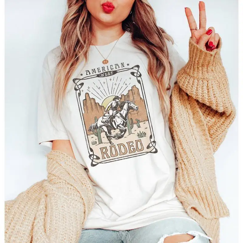 American Rodeo Cowboy T-shirt Western Cowboy Horse Desert Cactus Retro Women Shirt
American Rodeo Cowboy T-shirt Western Cowboy Horse Desert Cactus Retro Women Shirt