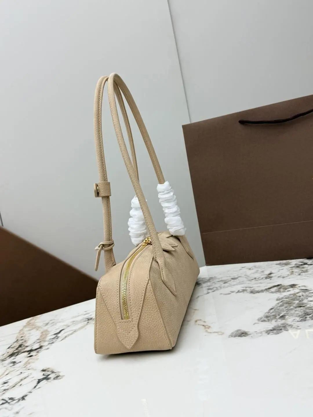 Leather shoulder bag with a smooth elongated silhouette, featuring a top zipper and shoulder strap.
Leather shoulder bag with a smooth elongated silhouette, featuring a top zipper and shoulder strap.