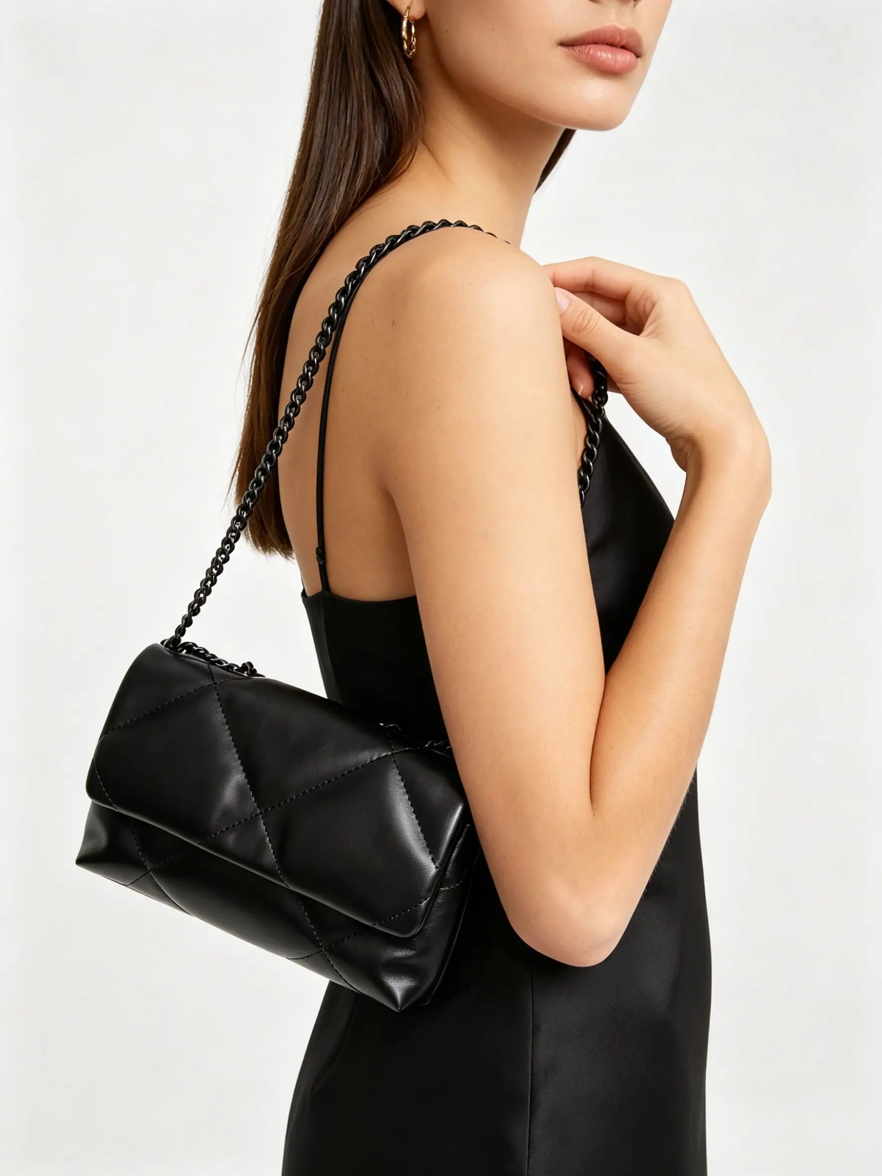 The single-shoulder bag is made of high-quality black leather, featuring a classic diamond-quilted pattern and equipped with a matching black chain shoulder strap, presenting an elegant monochromatic look.
The single-shoulder bag is made of high-quality black leather, featuring a classic diamond-quilted pattern and equipped with a matching black chain shoulder strap, presenting an elegant monochromatic look.