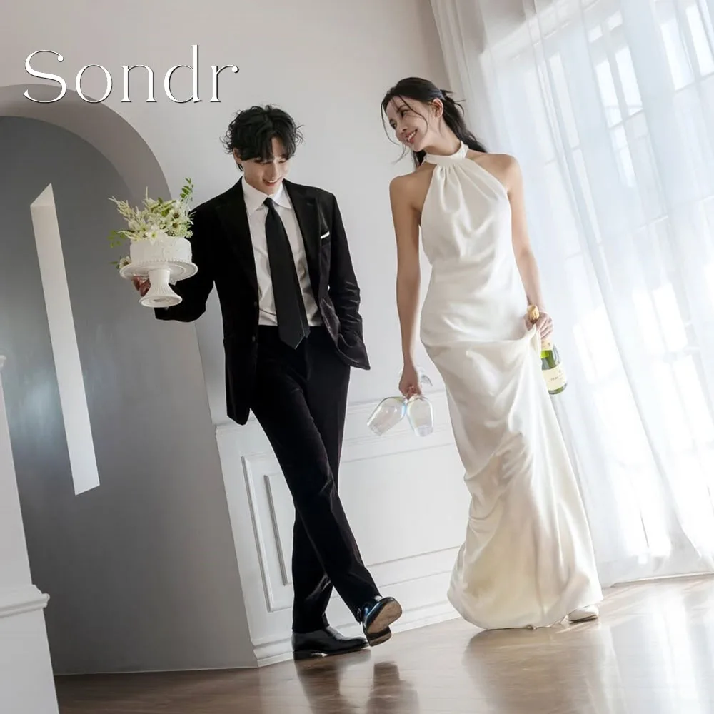 Свадебные платья Sondr: индивидуальный пошив, высокий воротник, драпировка, элегантные, простые, силуэт «футляр», без рукавов, с открытой спиной, цвет слоновой кости.
Свадебные платья Sondr: индивидуальный пошив, высокий воротник, драпировка, элегантные, простые, силуэт «футляр», без рукавов, с открытой спиной, цвет слоновой кости.