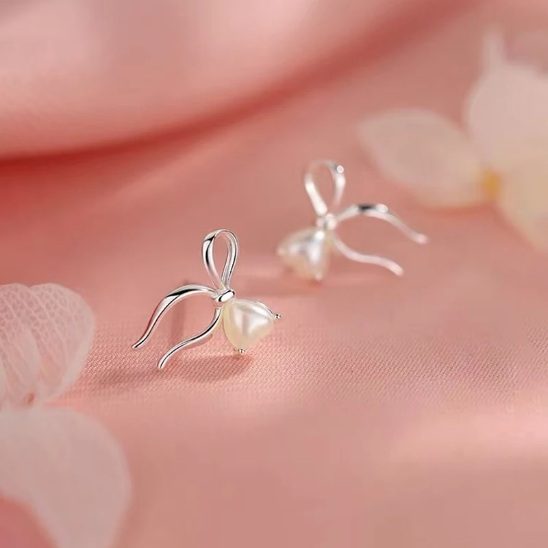 Настоящее серебро 925, серьги-гвоздики с жемчугом и бантом в форме сердца для женщин, классические ювелирные изделия, минималистичные аксессуары
Настоящее серебро 925, серьги-гвоздики с жемчугом и бантом в форме сердца для женщин, классические ювелирные изделия, минималистичные аксессуары