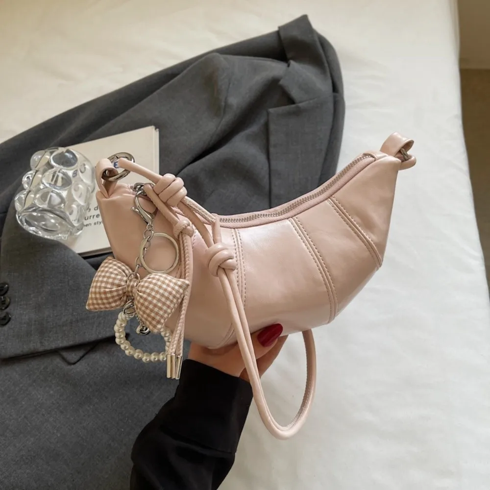 Элегантная сумка-круассан через плечо из искусственной кожи в корейском стиле, сумка-пельмень на одно плечо, однотонная, с бантом и жемчужным кулоном, сумка кроссбоди
Элегантная сумка-круассан через плечо из искусственной кожи в корейском стиле, сумка-пельмень на одно плечо, однотонная, с бантом и жемчужным кулоном, сумка кроссбоди