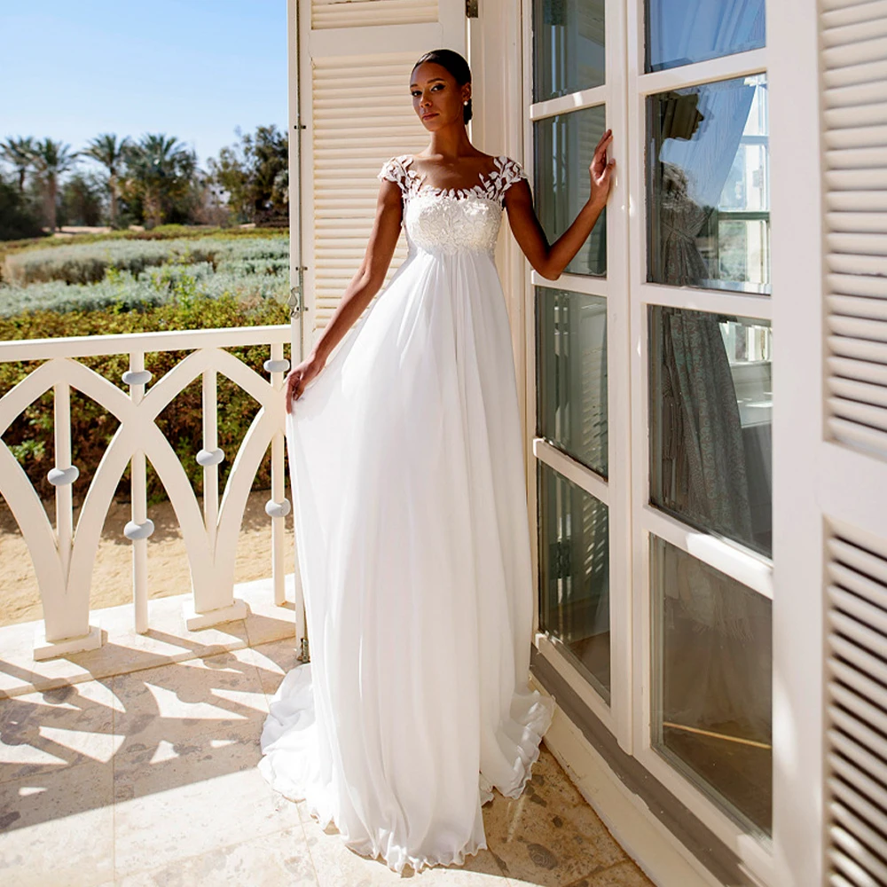 Свадебное платье А-силуэта из шифона с кружевными вставками, завышенной талией, струящейся юбкой и шлейфом для курортной фотосессии.
Свадебное платье А-силуэта из шифона с кружевными вставками, завышенной талией, струящейся юбкой и шлейфом для курортной фотосессии.