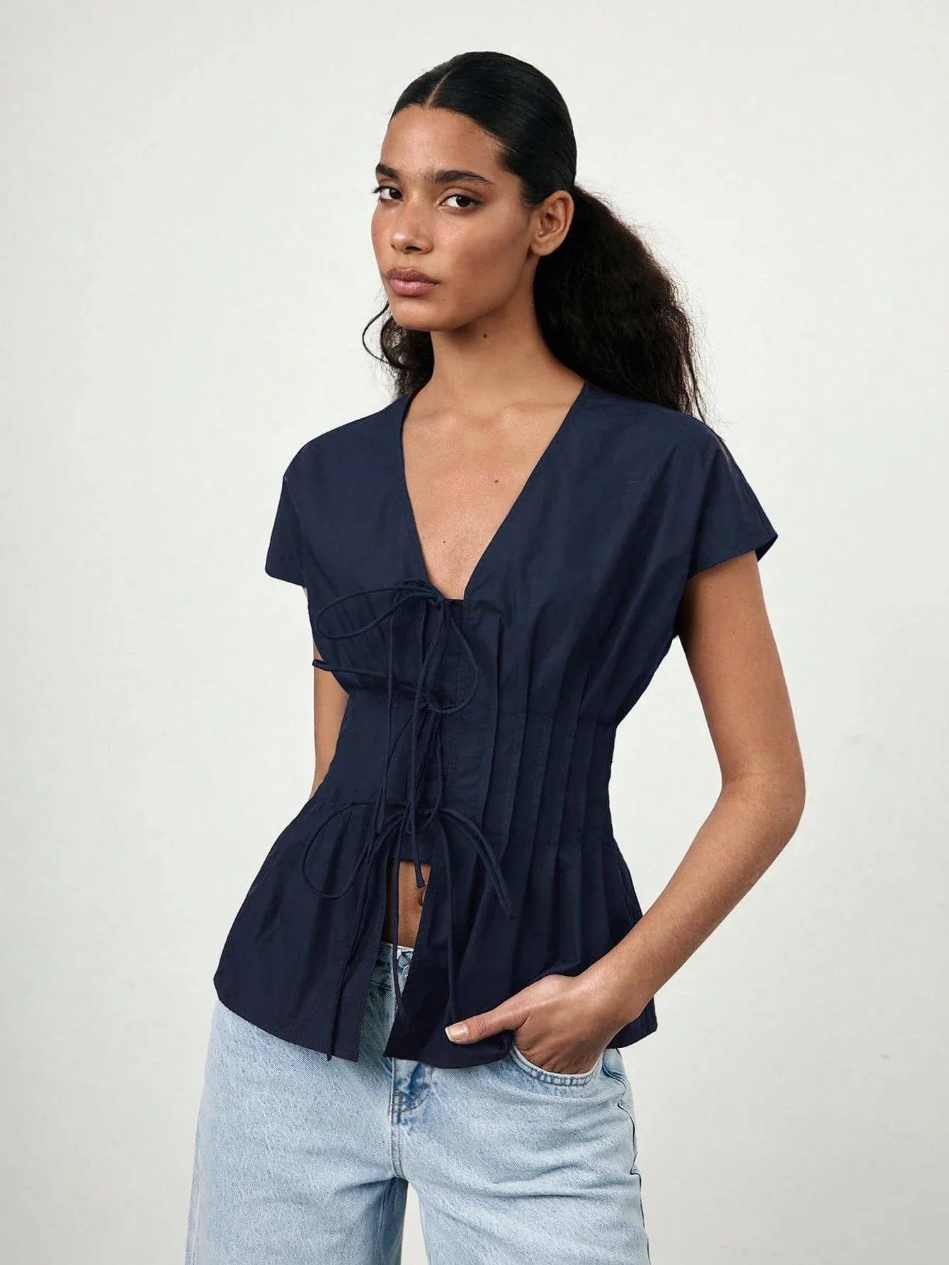 Темно-синяя блузка с V-образным вырезом, завязками спереди, плиссированной талией и рукавами-крылышками
Темно-синяя блузка с V-образным вырезом, завязками спереди, плиссированной талией и рукавами-крылышками