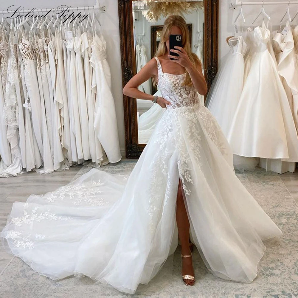 Lceland Poppy A Line Square Neck Illusion Tulle Wedding Dresses Sleeveless Lace Appliques Bridal Gowns with High Slit
Lceland Poppy A Line Square Neck Illusion Tulle Wedding Dresses Sleeveless Lace Appliques Bridal Gowns with High Slit