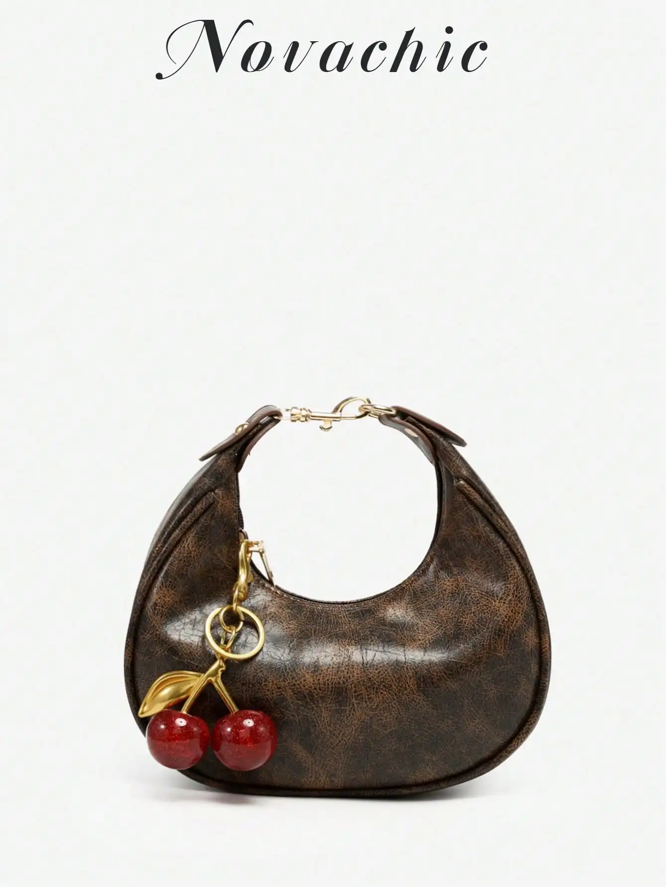 Сумка-полумесяц для ношения под мышкой с подвеской в виде вишни, из состаренной коричневой искусственной кожи.
Сумка-полумесяц для ношения под мышкой с подвеской в виде вишни, из состаренной коричневой искусственной кожи.