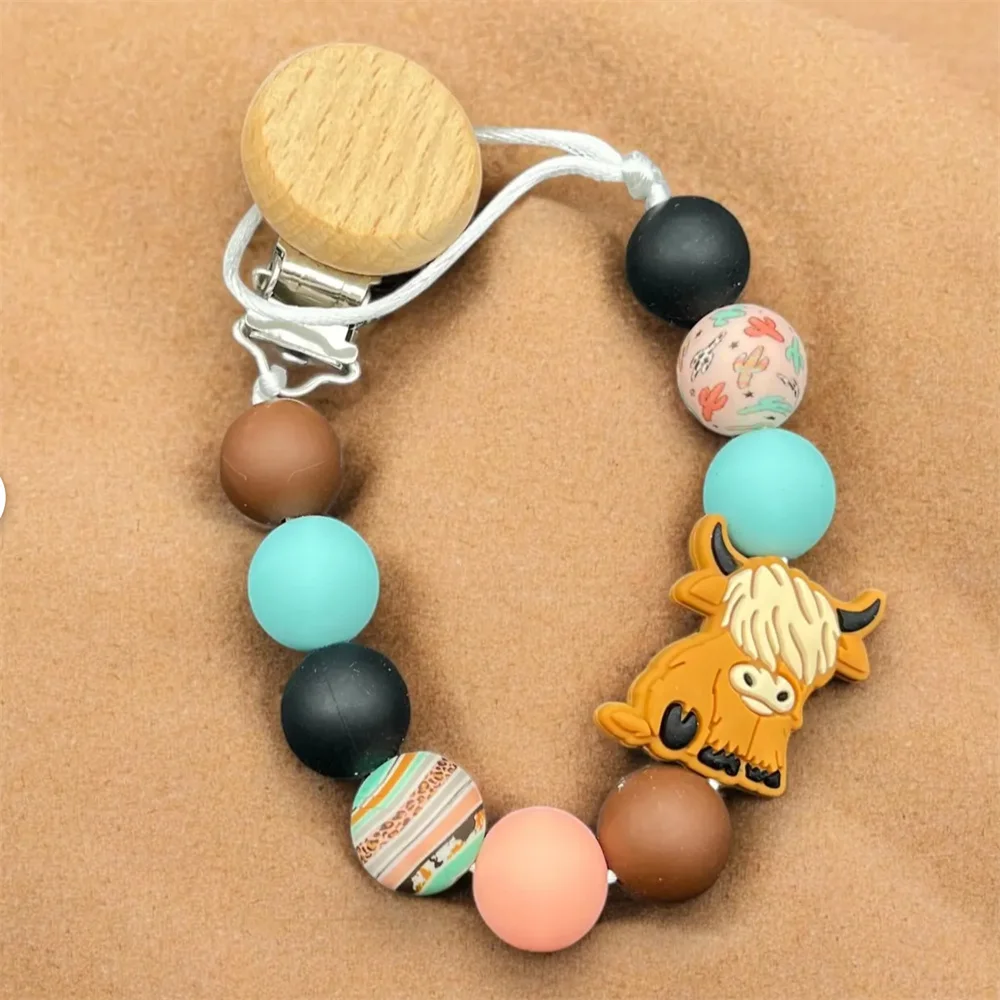 Силиконовая цепочка для соски Highland Cow Design с деревянным зажимом для ребенка -
Силиконовая цепочка для соски Highland Cow Design с деревянным зажимом для ребенка -