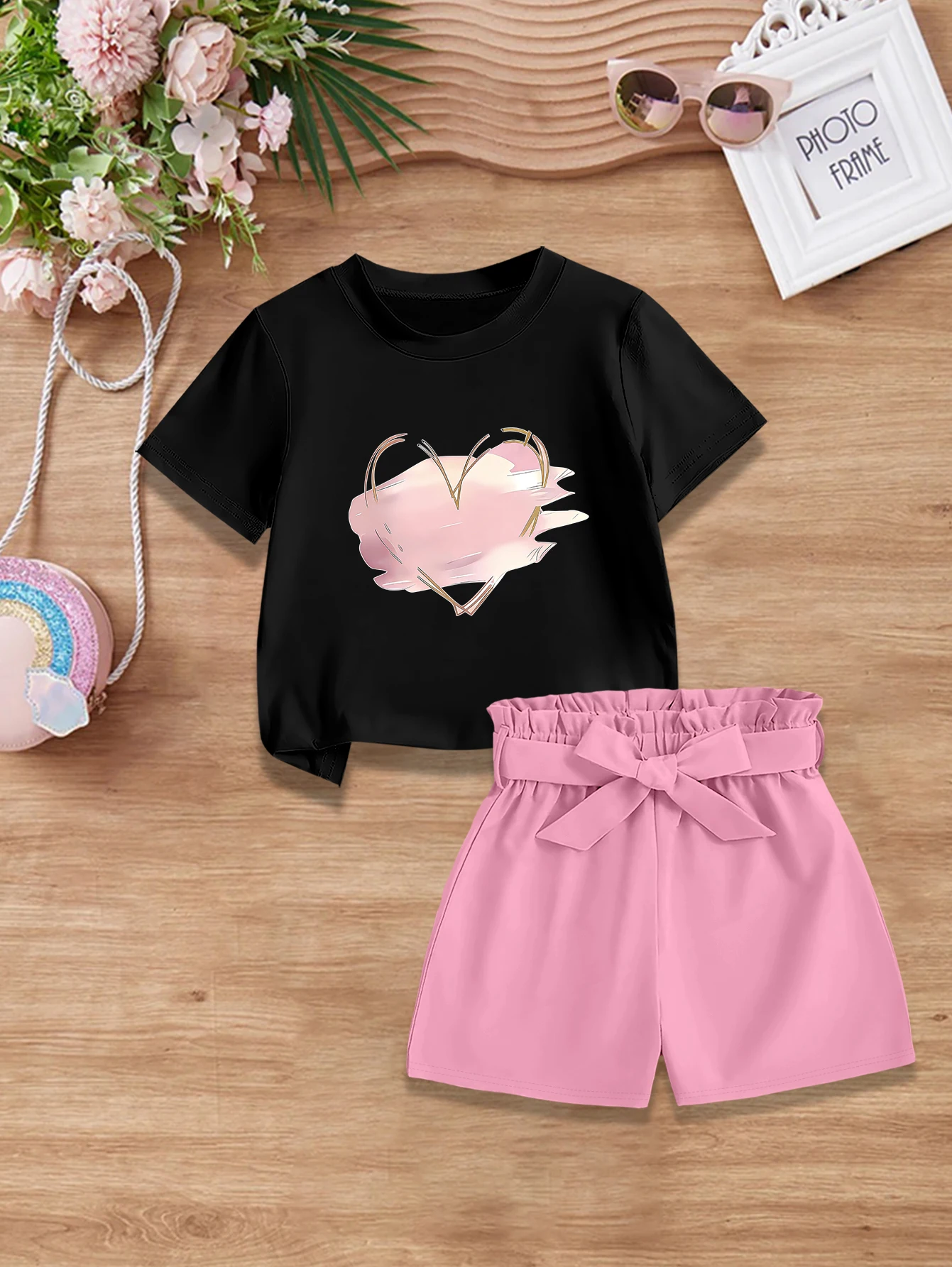 Комплект из 2 предметов: летний милый наряд для девочек на День святого Валентина, футболка с принтом в виде сердечек и мультяшным граффити + тканевые шорты с бантом.
Комплект из 2 предметов: летний милый наряд для девочек на День святого Валентина, футболка с принтом в виде сердечек и мультяшным граффити + тканевые шорты с бантом.