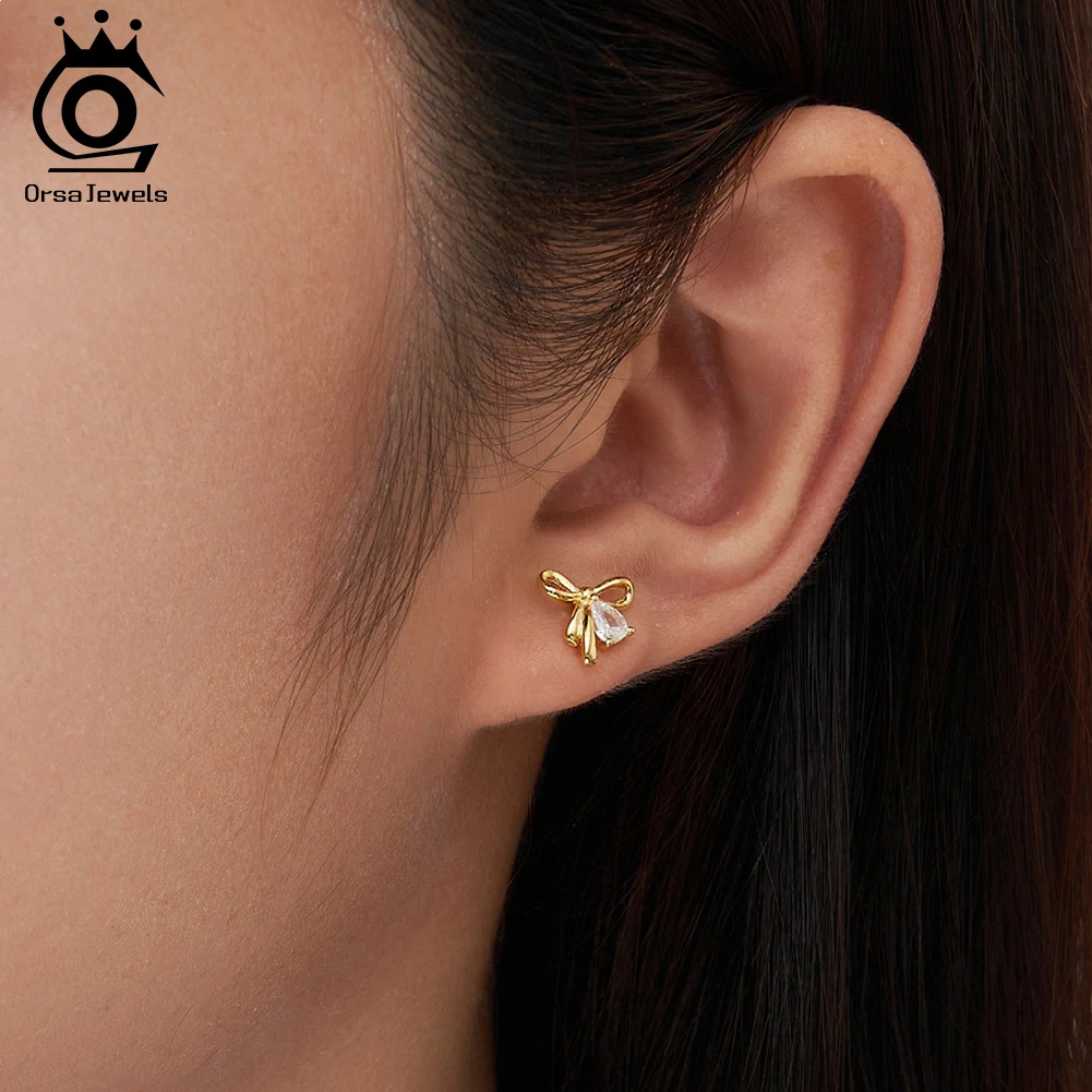 Серьги-гвоздики ORSA JEWELS с изящным бантом из кубического циркония, модный минималистичный стиль, свадебные, из стерлингового серебра 925 пробы, украшение для ушей в виде банта, SE409
Серьги-гвоздики ORSA JEWELS с изящным бантом из кубического циркония, модный минималистичный стиль, свадебные, из стерлингового серебра 925 пробы, украшение для ушей в виде банта, SE409