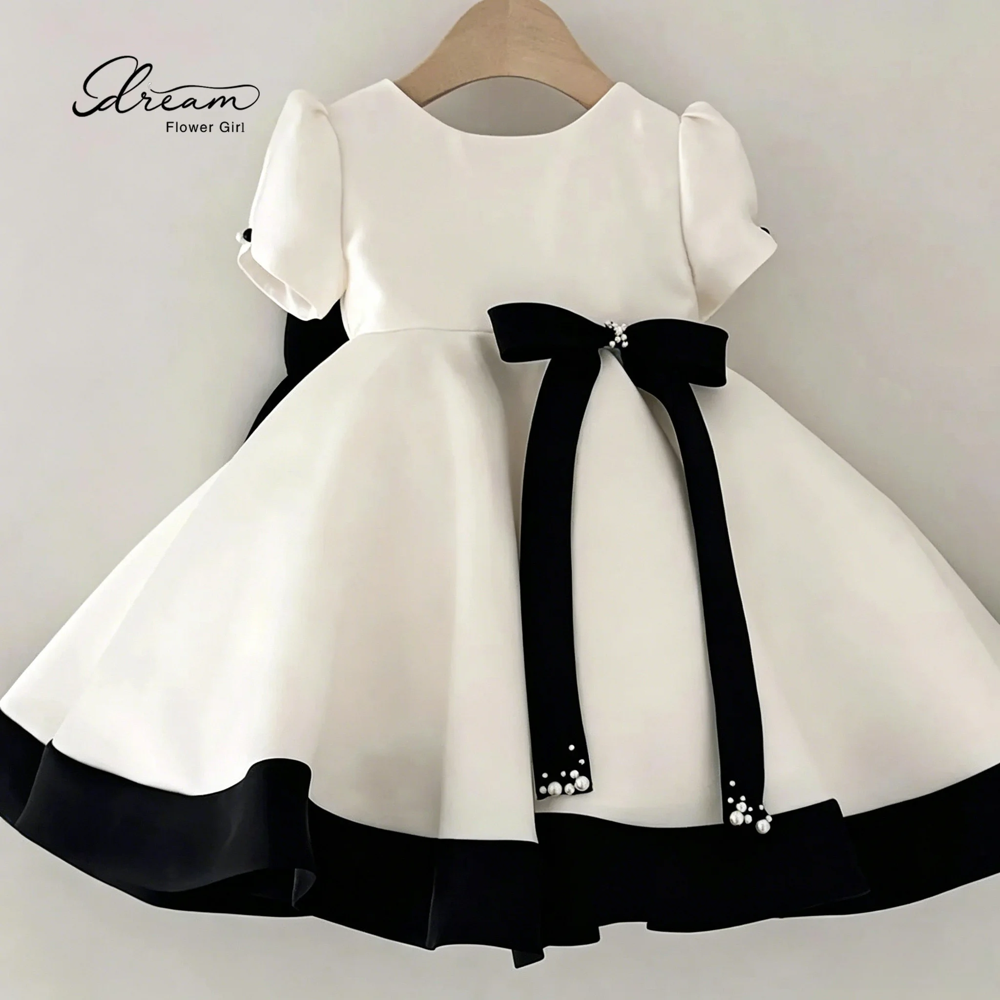 Fashionable flower girl's white short-sleeved fluffy ball gown, knee-length evening dress, with a bow at the back.
Fashionable flower girl's white short-sleeved fluffy ball gown, knee-length evening dress, with a bow at the back.