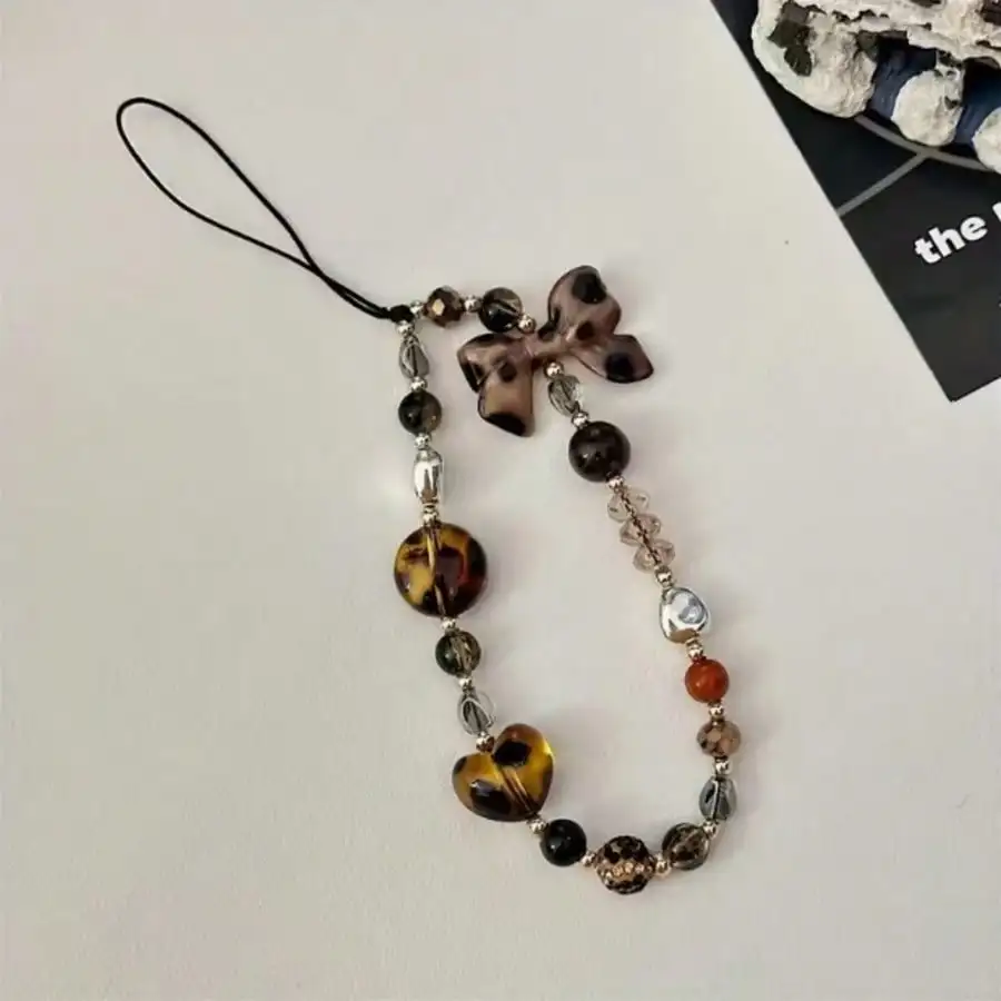 A fashionable mobile phone lanyard adorned with leopard print bow and bead decorations, used as an anti lost phone lanyard
A fashionable mobile phone lanyard adorned with leopard print bow and bead decorations, used as an anti lost phone lanyard