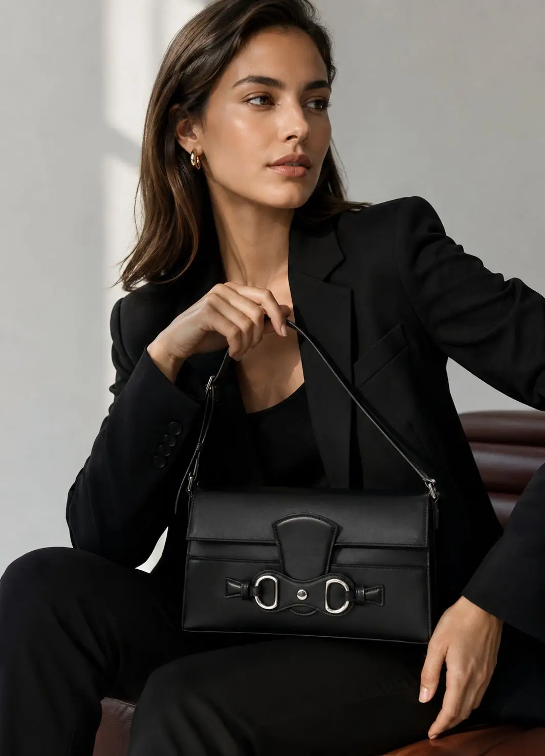 Smooth black leather shoulder bag with a structured silhouette, signature equestrian-style buckle detail, and a single top handle.
Smooth black leather shoulder bag with a structured silhouette, signature equestrian-style buckle detail, and a single top handle.
