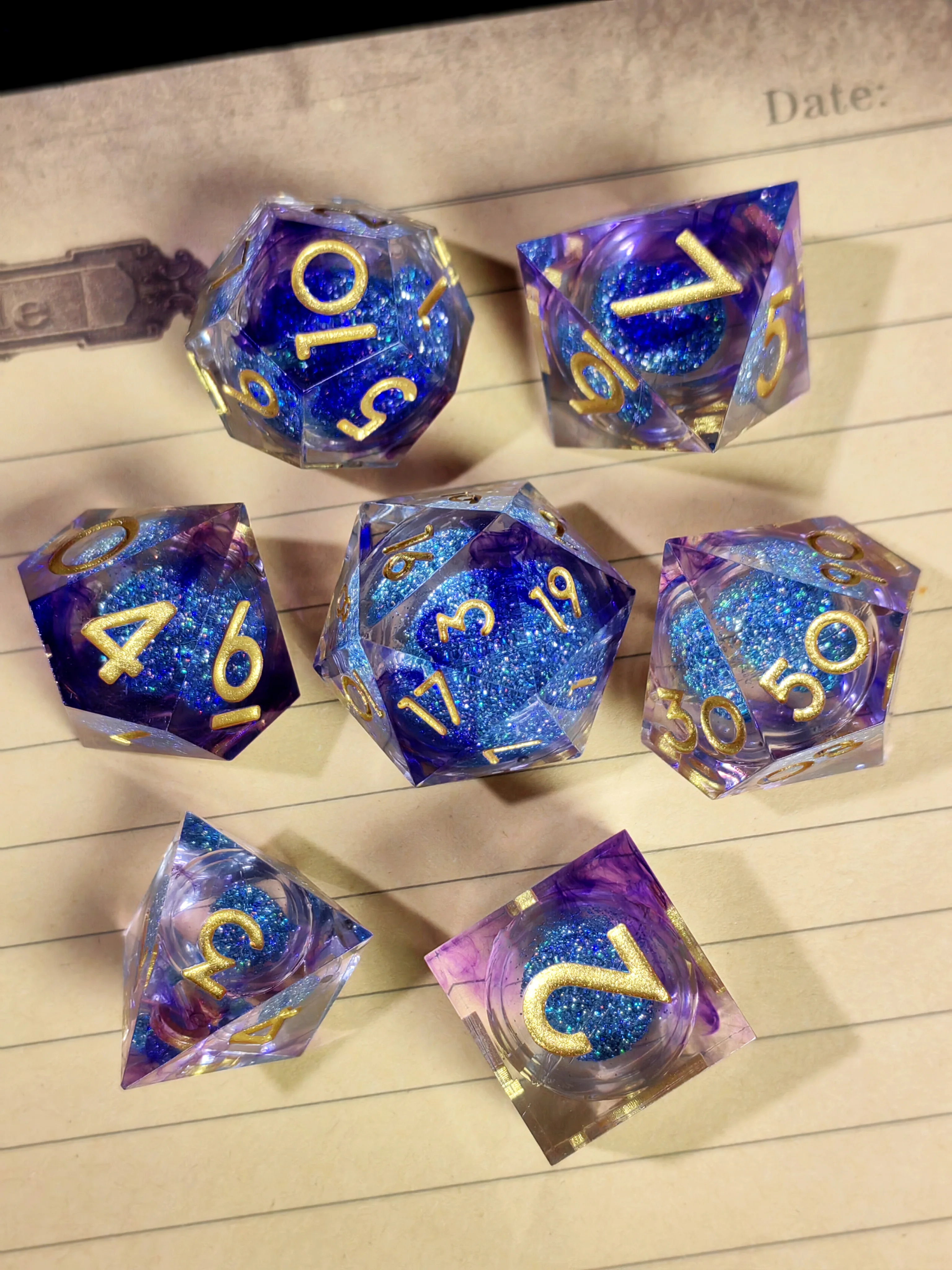 DnD Dice Set – 7 Piece Sharp Edge Resin Dice, Blue Sand, Transparent with Gold Numbers, for Dungeons & Dragons, RPG Games
DnD Dice Set – 7 Piece Sharp Edge Resin Dice, Blue Sand, Transparent with Gold Numbers, for Dungeons & Dragons, RPG Games