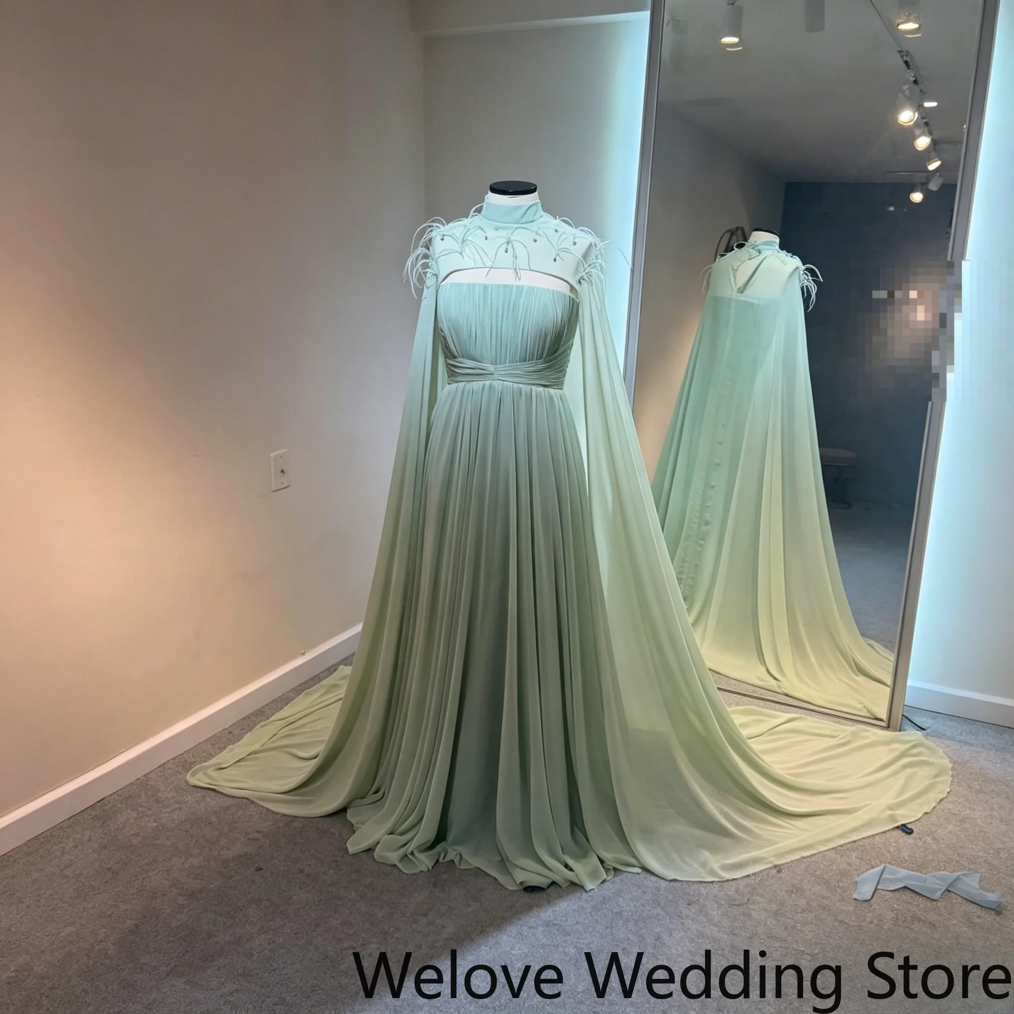 Formal Evening Dress with High Neck Cut‑Out Detail Dramatic Floor‑Length Cape Sleeves Delicate Feather & Bead Embellishments
Formal Evening Dress with High Neck Cut‑Out Detail Dramatic Floor‑Length Cape Sleeves Delicate Feather & Bead Embellishments