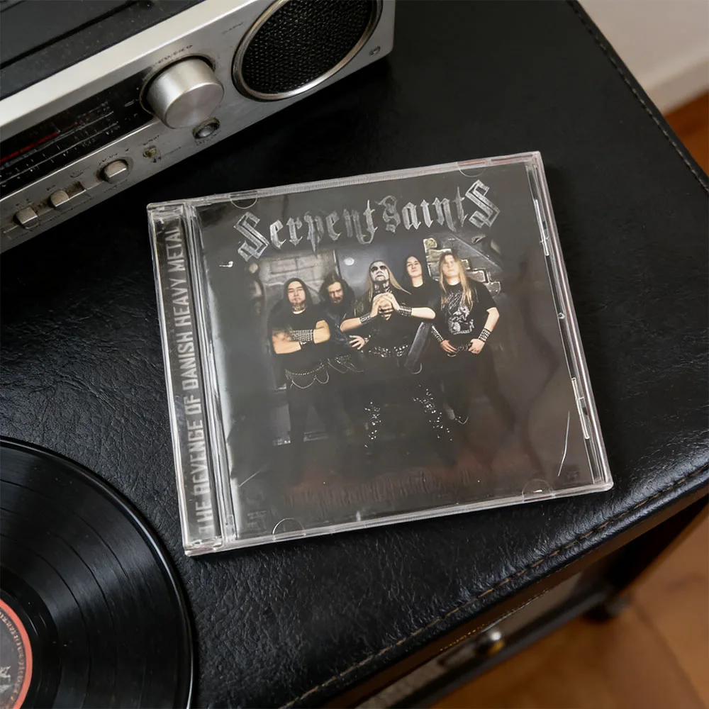 CD This Is The Album "The Revenge of Danish Heavy Metal" By The Danish Heavy Metal Band Serpent Saints. The Cover Features
CD This Is The Album "The Revenge of Danish Heavy Metal" By The Danish Heavy Metal Band Serpent Saints. The Cover Features
