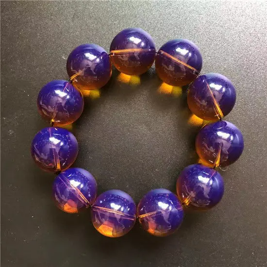 Amber beeswax gold brown amber violet single circle bead bracelet with fluorescence in natural light black background discolorai
Amber beeswax gold brown amber violet single circle bead bracelet with fluorescence in natural light black background discolorai