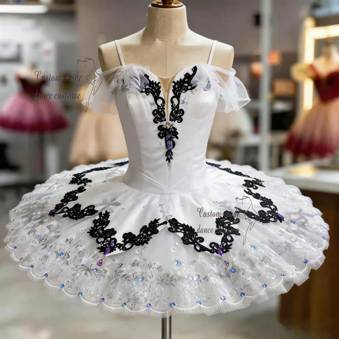Handcrafted luxury white professional tutu, off-shoulder sheer sleeve design, hand-sewn black floral lace and sapphire rhineston
Handcrafted luxury white professional tutu, off-shoulder sheer sleeve design, hand-sewn black floral lace and sapphire rhineston