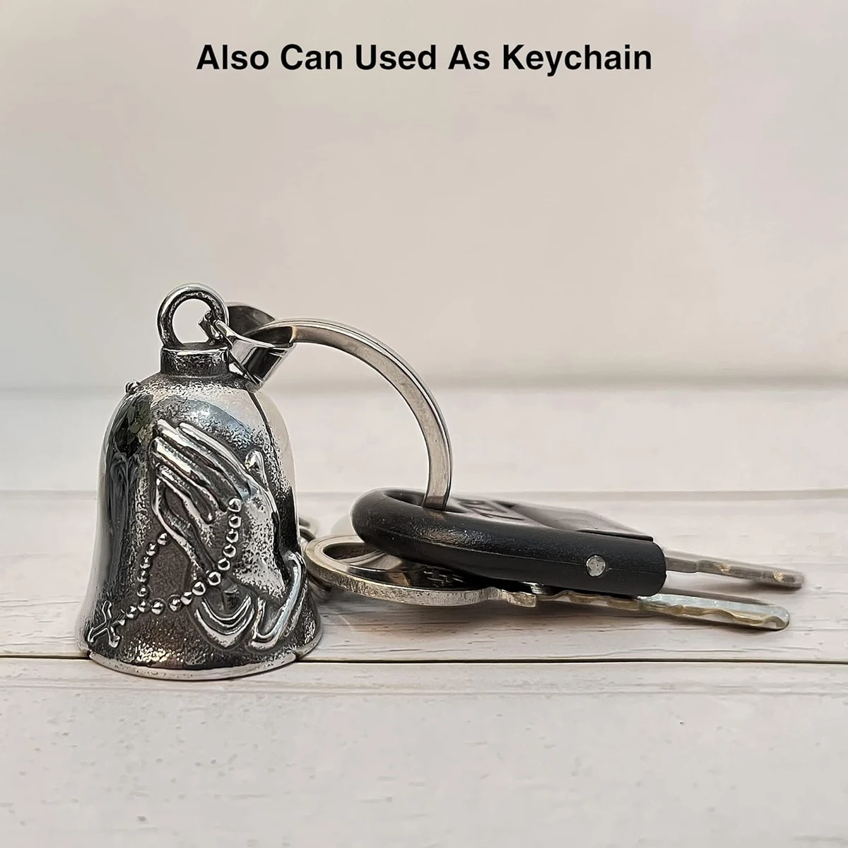 A retro-style metal motorcycle pendant, with a bell-shaped design and engraved with a pattern featuring a praying hand.
A retro-style metal motorcycle pendant, with a bell-shaped design and engraved with a pattern featuring a praying hand.