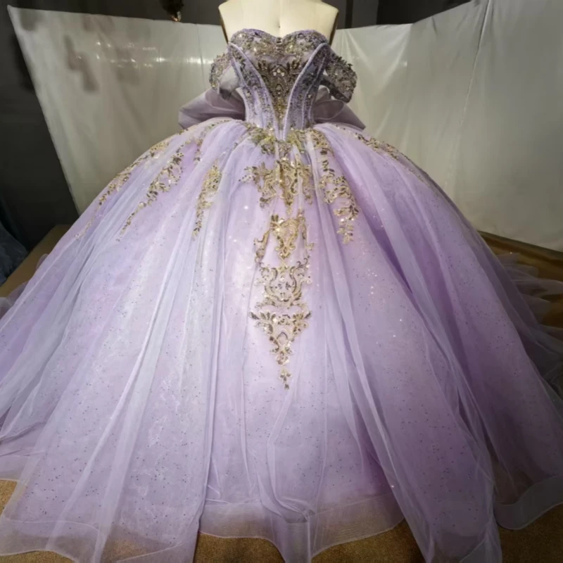 Светло-сиреневые блестящие платья Quinceanera с открытыми плечами, золотая аппликация, кружево, бисер, кристалл, бант, тюль, вечеринка, день рождения, сладкий 16 
Светло-сиреневые блестящие платья Quinceanera с открытыми плечами, золотая аппликация, кружево, бисер, кристалл, бант, тюль, вечеринка, день рождения, сладкий 16