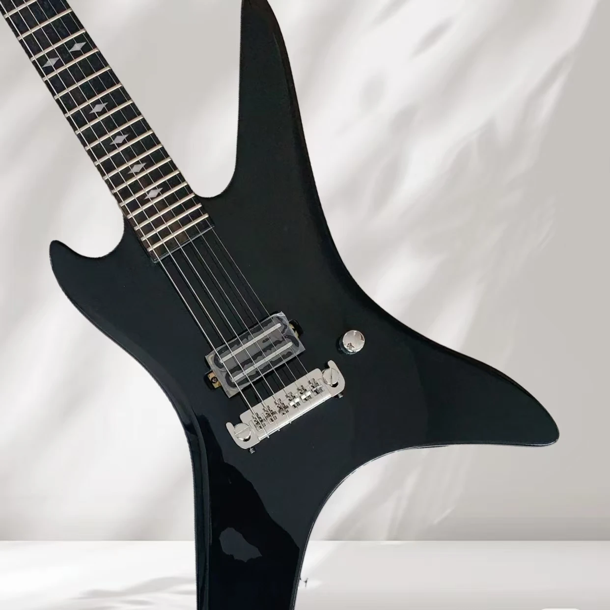 Irregular 24 Frets glossy black electric guitar, wraparound tail wing, single-bridge pickup 
Irregular 24 Frets glossy black electric guitar, wraparound tail wing, single-bridge pickup