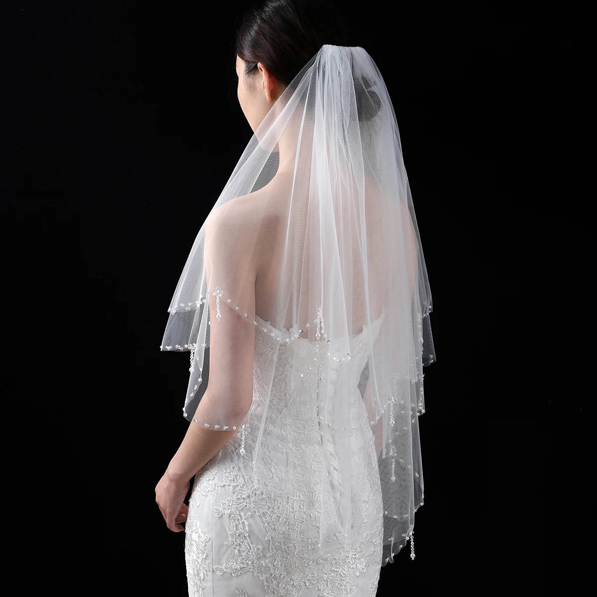 A white elegant bridal veil adorned with beaded waist length veils suitable for women's weddings
A white elegant bridal veil adorned with beaded waist length veils suitable for women's weddings