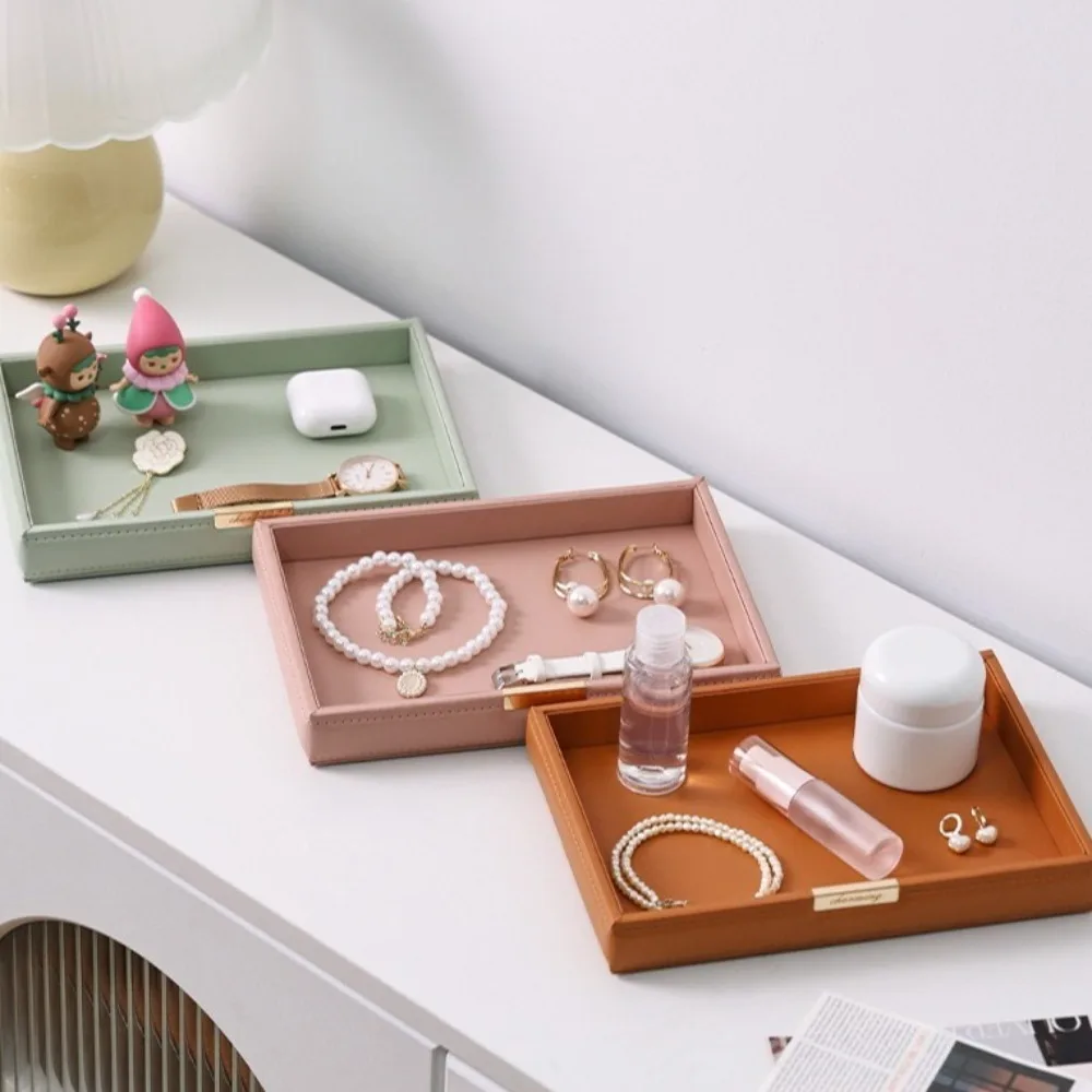 Скандинавский настольный поднос для хранения, квадратный элегантный ящик для хранения ювелирных изделий, многофункциональный кожаный декоративный поднос для туалетного столика для гостиной
Скандинавский настольный поднос для хранения, квадратный элегантный ящик для хранения ювелирных изделий, многофункциональный кожаный декоративный поднос для туалетного столика для гостиной