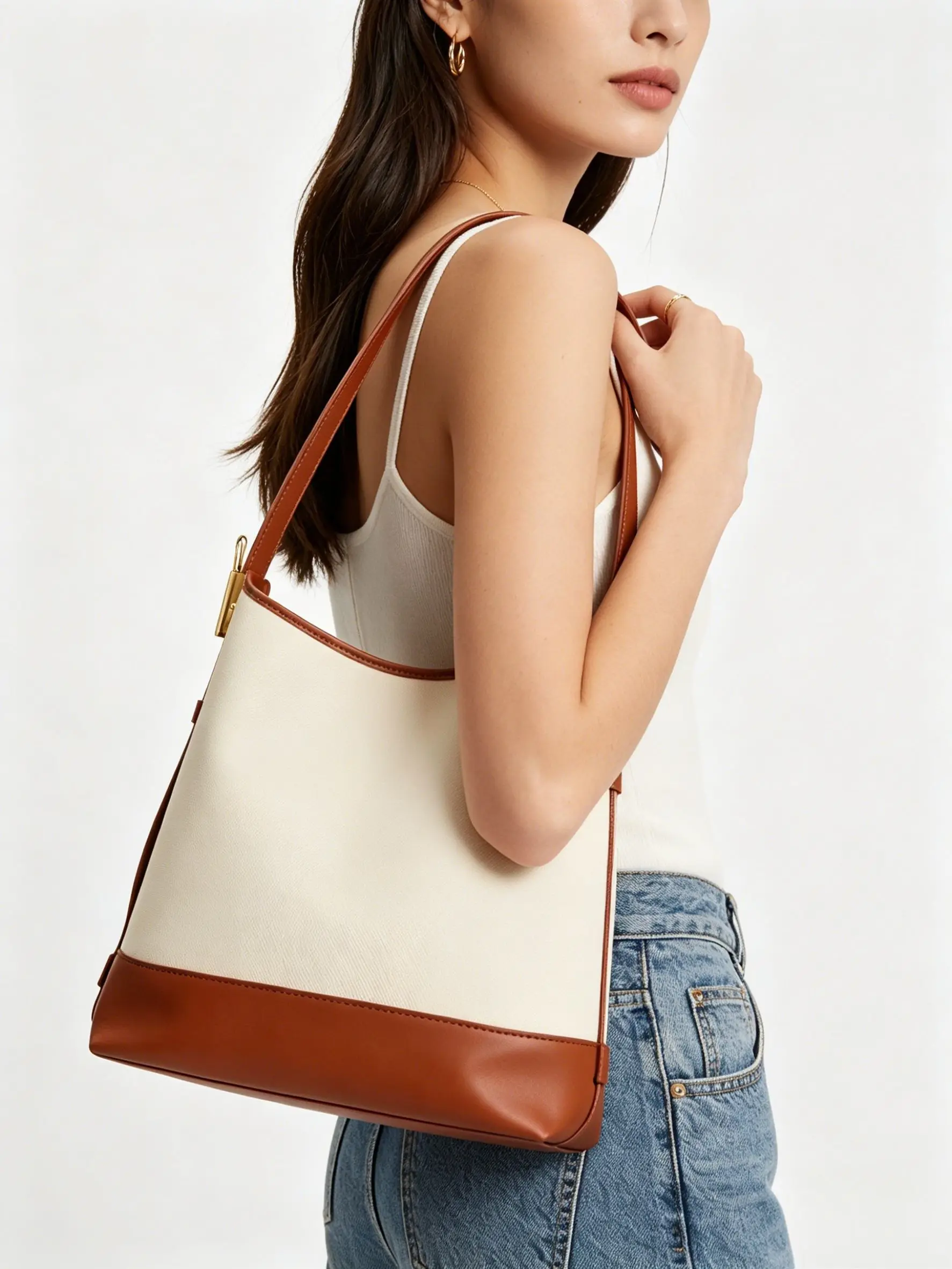 Two-tone canvas and leather bucket bag with brown leather trim and gold hardware.
Two-tone canvas and leather bucket bag with brown leather trim and gold hardware.