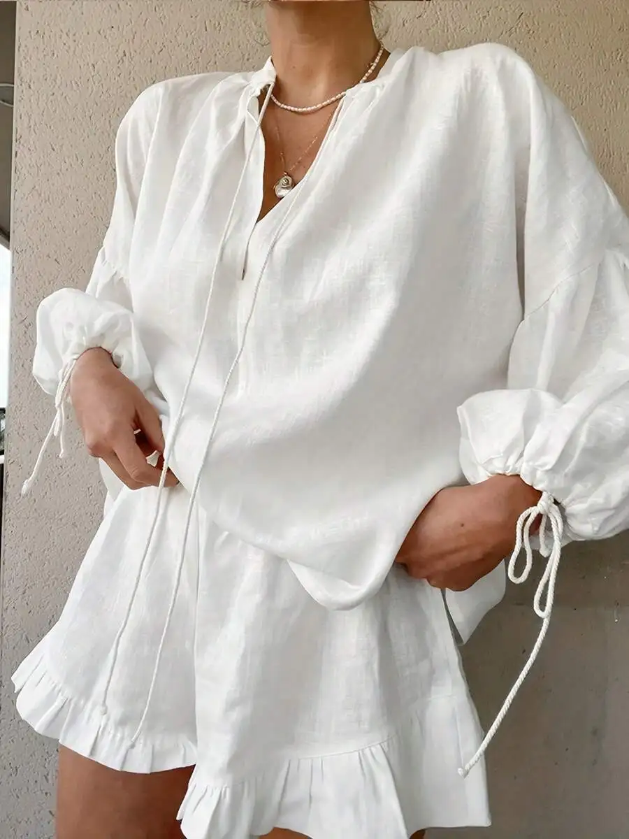 Women White 2-Piece Loungewear Set: Flowy V-Neck Tie-Up Blouse With Puffed Sleeves And Ruffled Elastic-Waist Shorts
Women White 2-Piece Loungewear Set: Flowy V-Neck Tie-Up Blouse With Puffed Sleeves And Ruffled Elastic-Waist Shorts