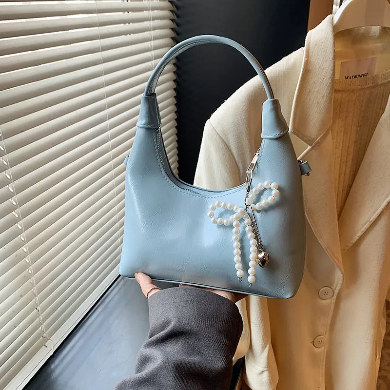 Модная женская сумка на весну-лето, однотонная, с изысканным бантом и жемчужным кулоном, из искусственной кожи, в корейском стиле, для повседневного использования, сумка-мессенджер.
Модная женская сумка на весну-лето, однотонная, с изысканным бантом и жемчужным кулоном, из искусственной кожи, в корейском стиле, для повседневного использования, сумка-мессенджер.