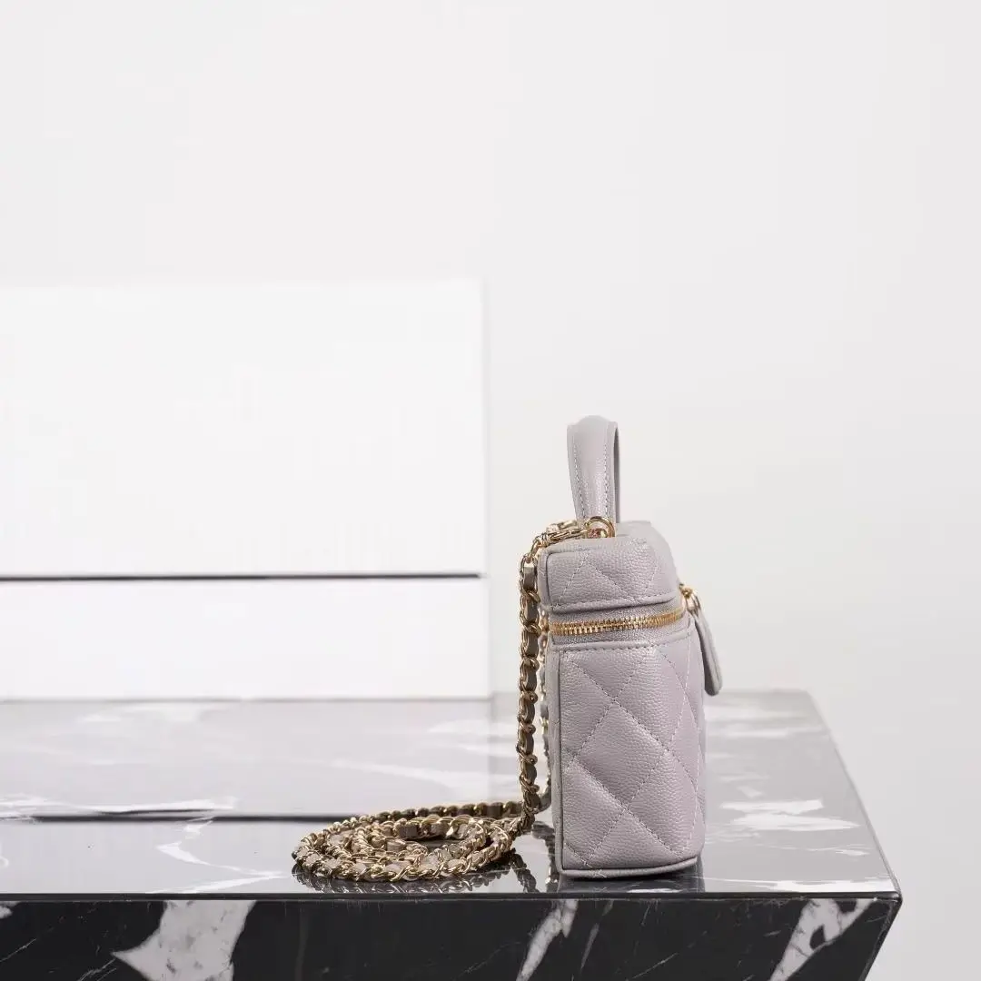 Neutral grey diamond-quilted leather box bag with gold-tone details, top handle and detachable chain strap.
Neutral grey diamond-quilted leather box bag with gold-tone details, top handle and detachable chain strap.