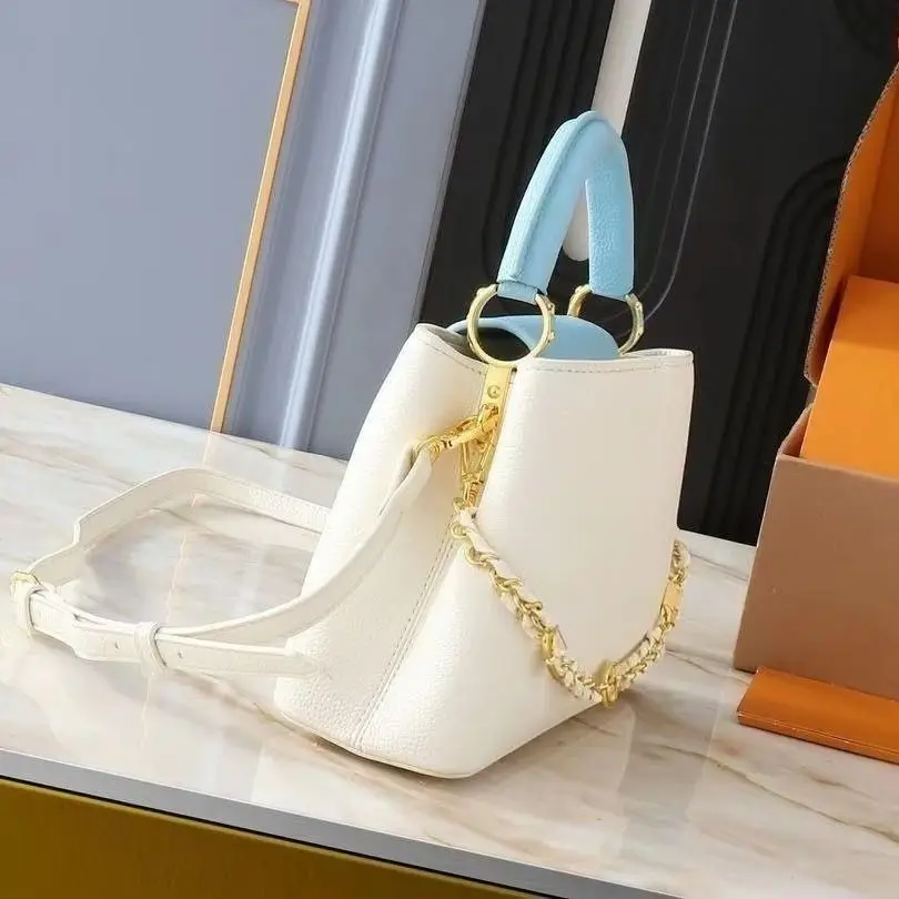 Structured trapezoid luxury handbag with a detachable and adjustable white leather crossbody strap, matte pebbled leather surface, and elegant color-block design.
Structured trapezoid luxury handbag with a detachable and adjustable white leather crossbody strap, matte pebbled leather surface, and elegant color-block design.