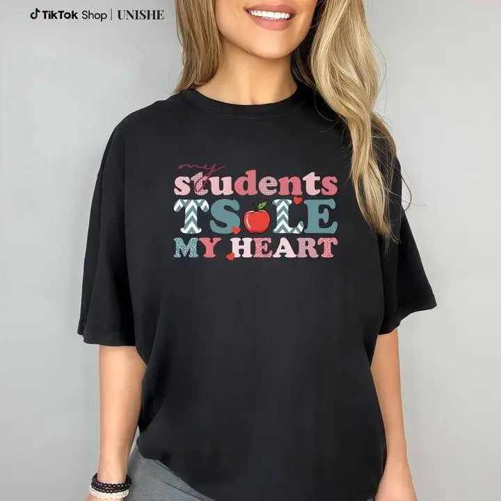 "Teacher's Sentimental T - Shirt: Displaying 'My Students Steal My Heart' In Patterned Letters With An Apple Motif"
"Teacher's Sentimental T - Shirt: Displaying 'My Students Steal My Heart' In Patterned Letters With An Apple Motif"