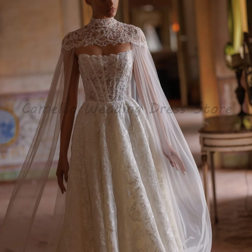 White Strapless Ball Gown Wedding Dress 2026 Luxury Lace Appliques Sheer Cape High Neck A-Line Bridal Gown With Train
White Strapless Ball Gown Wedding Dress 2026 Luxury Lace Appliques Sheer Cape High Neck A-Line Bridal Gown With Train