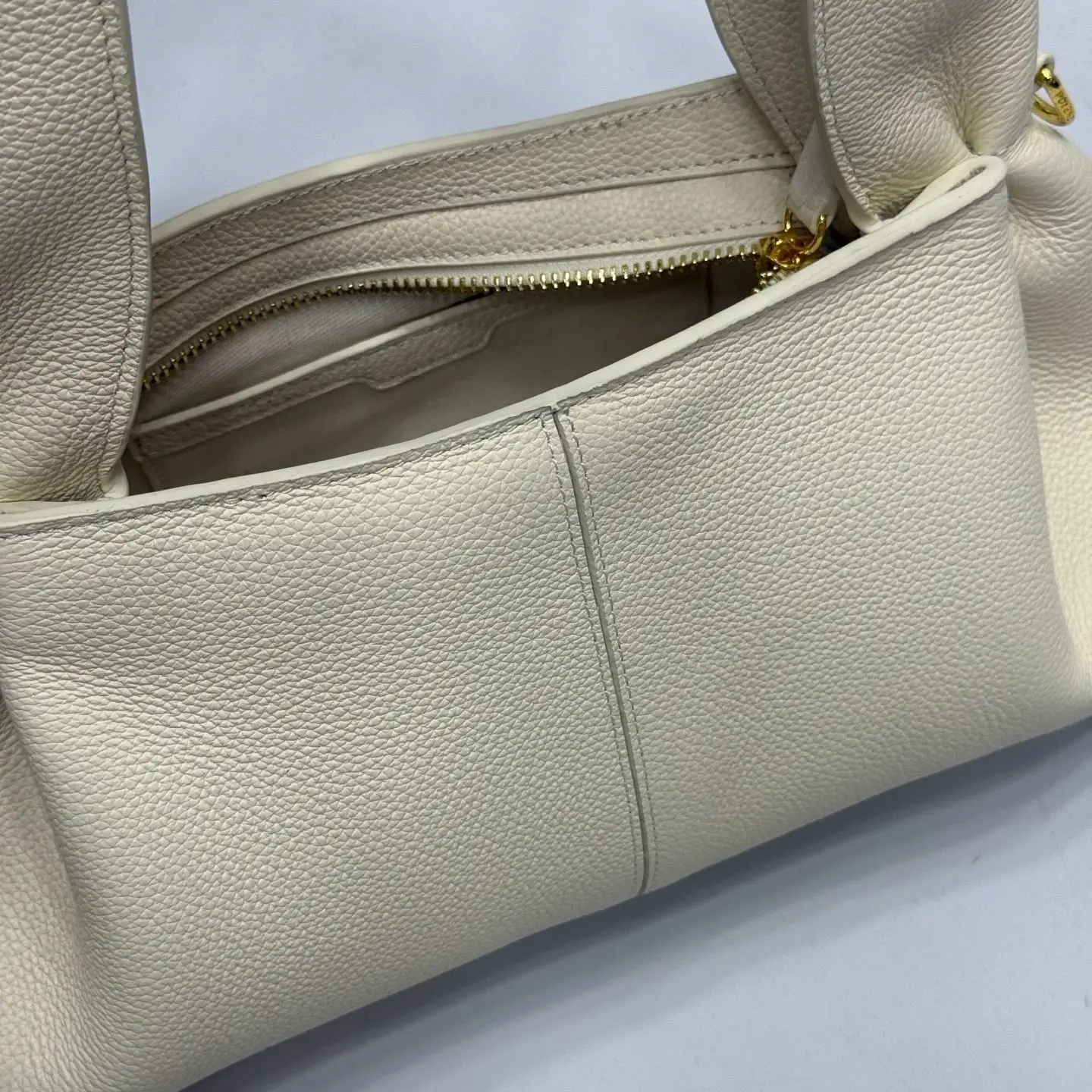 Soft leather casual shoulder bag with relaxed pleated side design, wide one-piece handle, and small gold hardware details.
Soft leather casual shoulder bag with relaxed pleated side design, wide one-piece handle, and small gold hardware details.