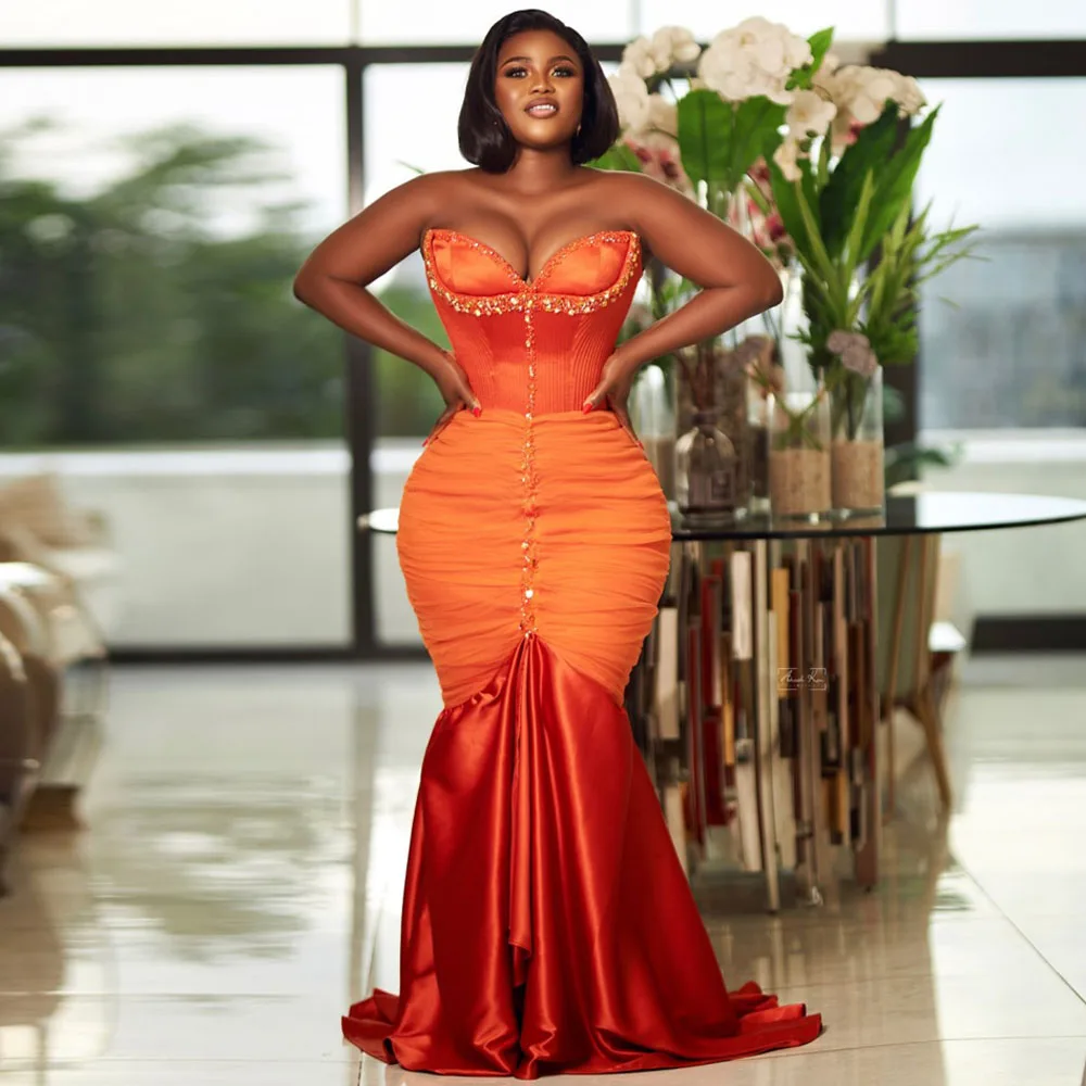 Orange Strapless Gown With Gold Embellishments And Ruched Fabric Features A Fitted Bodice And Flared Skirt Exuding Elegance And
Orange Strapless Gown With Gold Embellishments And Ruched Fabric Features A Fitted Bodice And Flared Skirt Exuding Elegance And