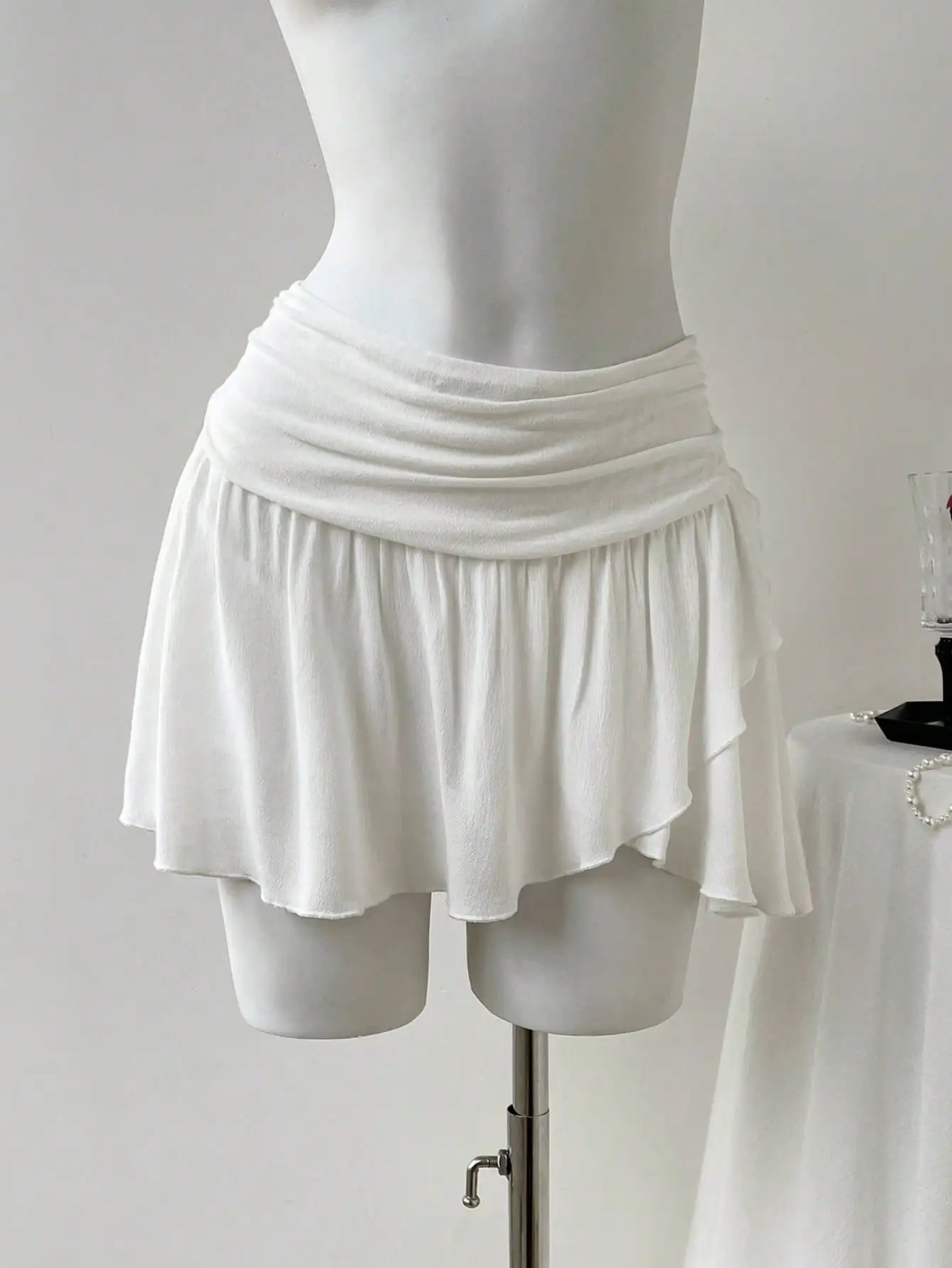 Белая асимметричная мини-юбка А-силуэта с драпировкой на талии и струящимся подолом
Белая асимметричная мини-юбка А-силуэта с драпировкой на талии и струящимся подолом