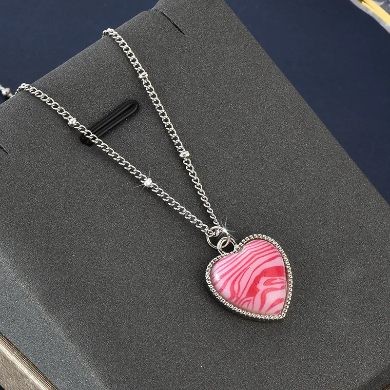 A hot girl wearing a pink zebra-striped heart-shaped necklace is a versatile collarbone chain fashion girl
A hot girl wearing a pink zebra-striped heart-shaped necklace is a versatile collarbone chain fashion girl