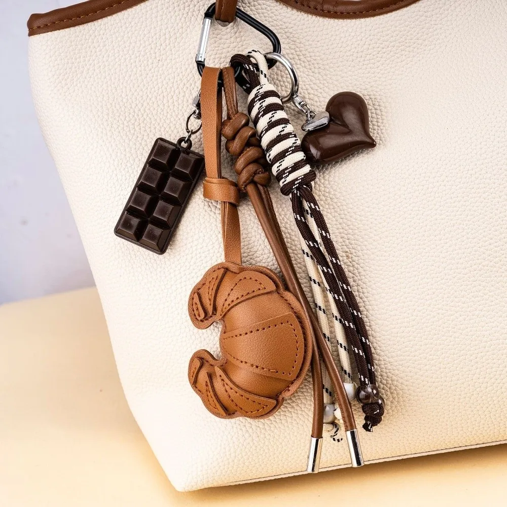 Новый плетеный брелок-цепочка в форме круассана, шоколада, с кожаным кулоном-сердцем для телефона и украшением для сумки
Новый плетеный брелок-цепочка в форме круассана, шоколада, с кожаным кулоном-сердцем для телефона и украшением для сумки